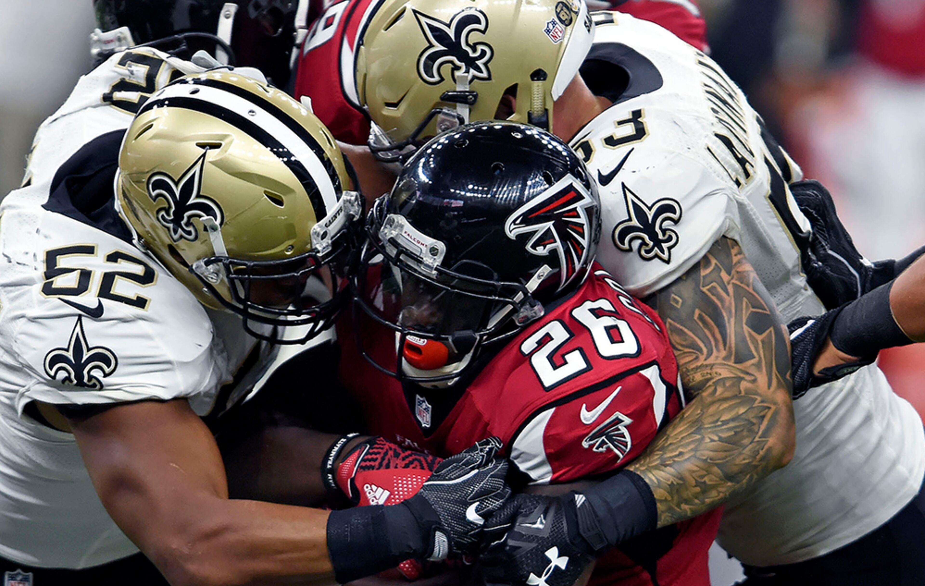 Falcons running back Tevin Coleman (26) is stopped by New Orleans Saints linebacker Craig Robertson (52) and linebacker James Laurinaitis (53) in the first half in New Orleans, Monday, Sept. 26, 2016