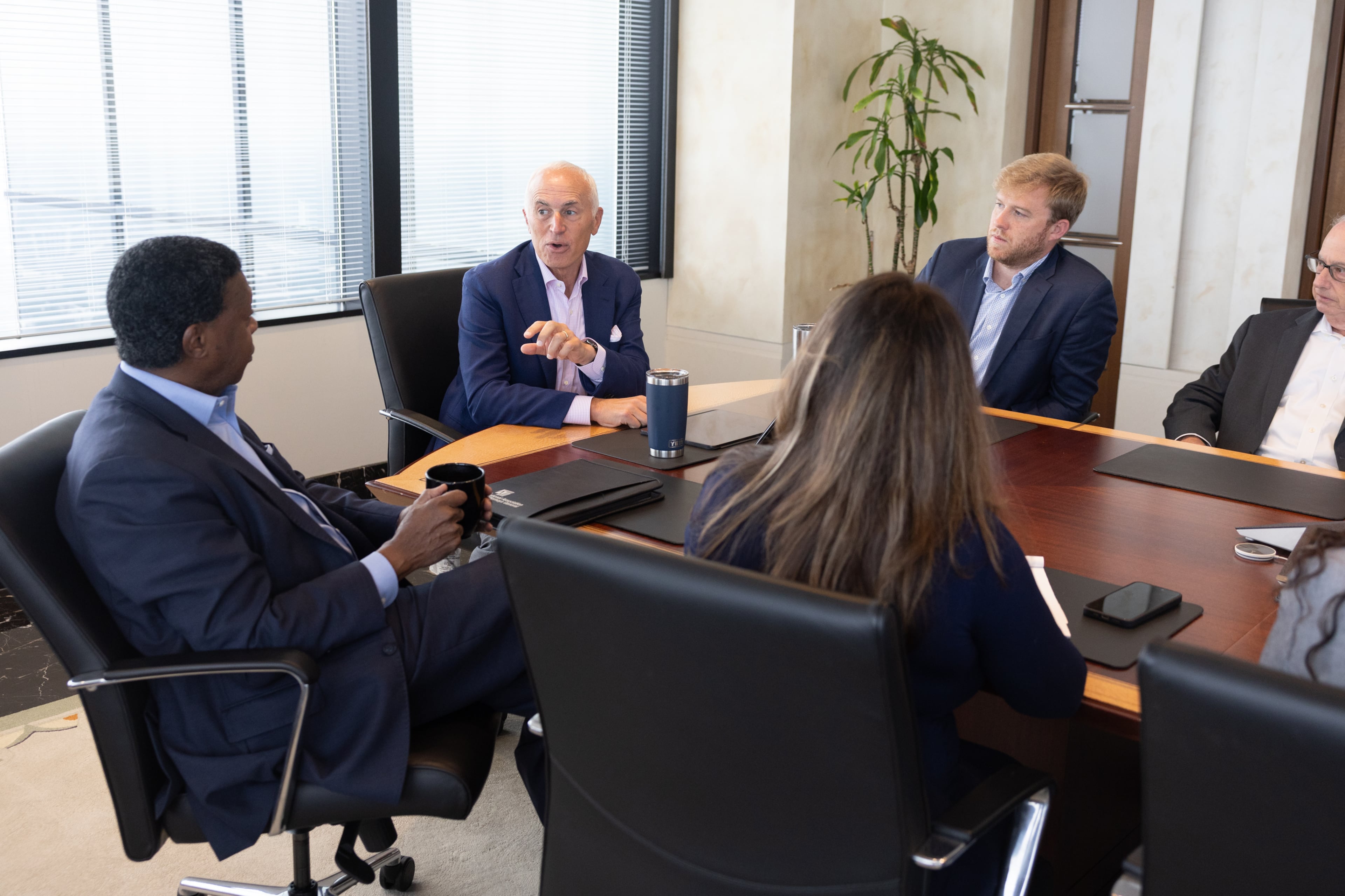 Eric Tanenblatt (center), Dentons' global chair of public policy and regulation, addresses Dentons' Thurbert Baker (left), former attorney general of Georgia, at a meeting at the law firm's Atlanta office last week. (Arvin Temkar/AJC)