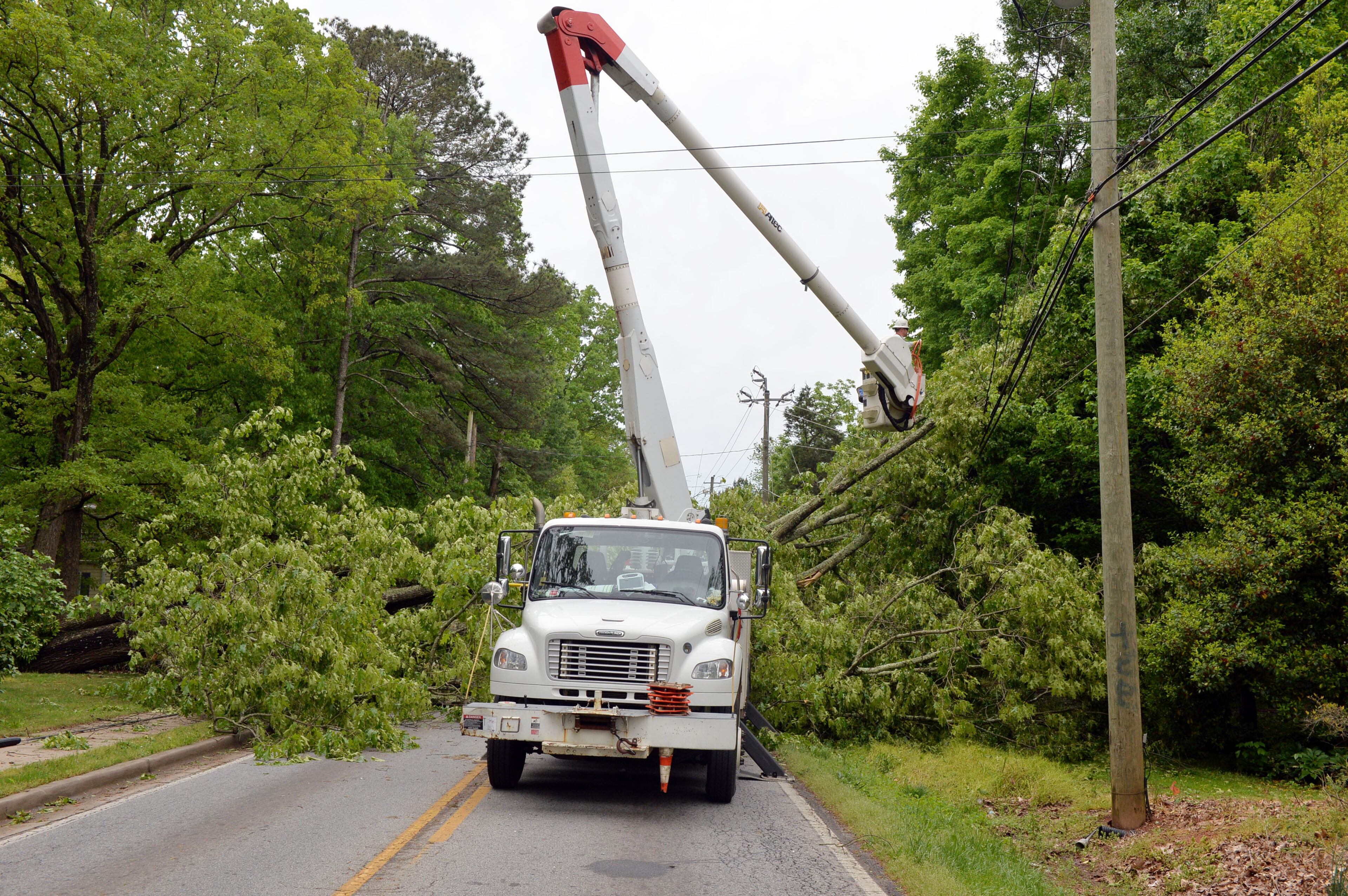 Georgia Power and Trees Inc crews work to remove a large tree that fell on power lines in the 1900 block of Idlewood Road in Tucker Tuesday April 29. 2014. KENT D. JOHNSON/KDJOHNSON@AJC.COM