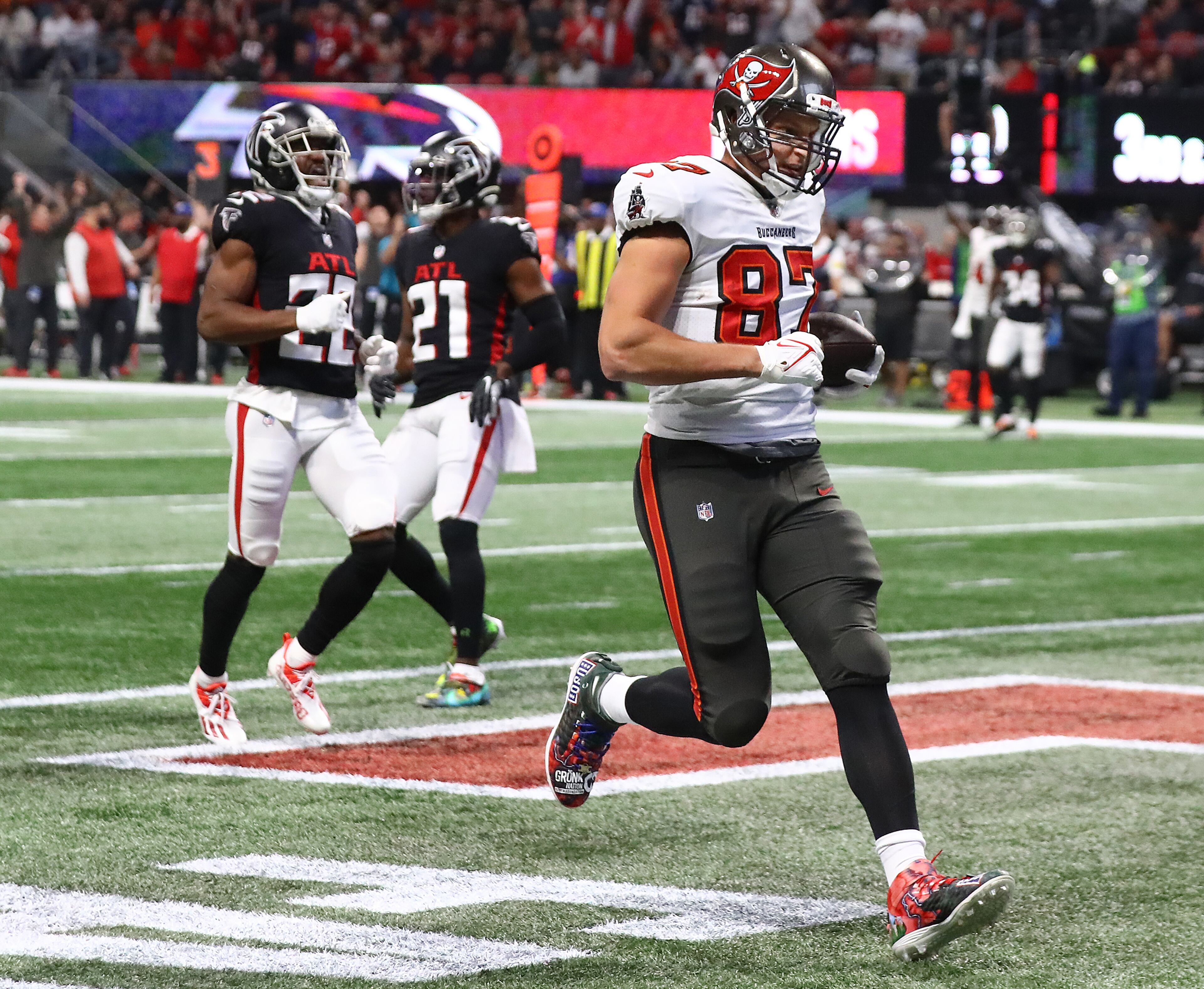 Buccaneers tight end Rob Gronkowski gets past Falcons defenders Fabian Moreau and Duron Harmon on a touchdown reception from Tom Brady to take a 20-10 lead over the Falcons during the second quarter in a NFL football game on Sunday, Dec 5, 2021, in Atlanta. (Curtis Compton / Curtis.Compton@ajc.com)