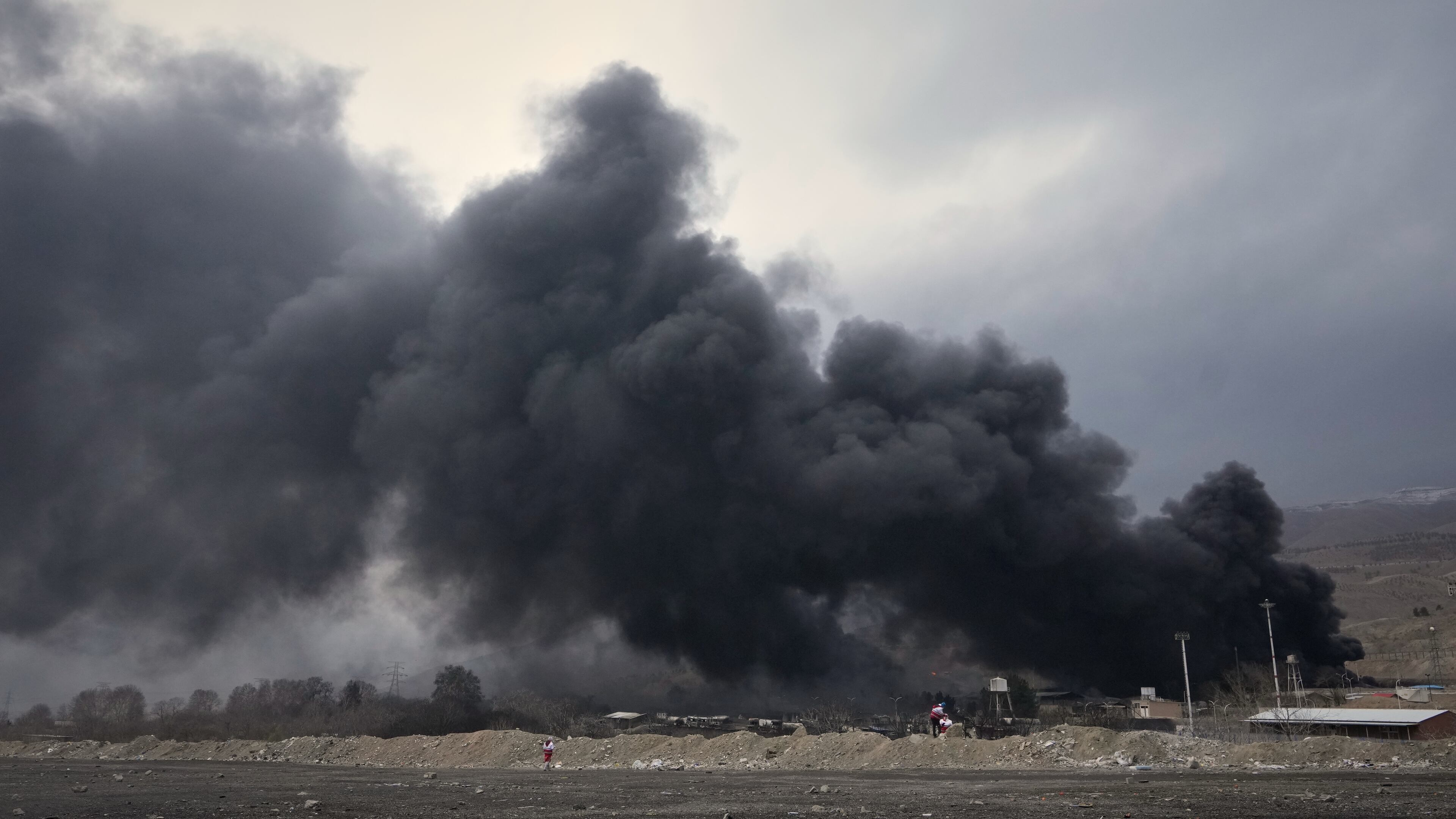 A thick plume of smoke rises from an oil storage facility hit by a U.S.-Israeli strike late Saturday in Tehran, Iran, Sunday, March 8, 2026. (AP Photo/Vahid Salemi)
