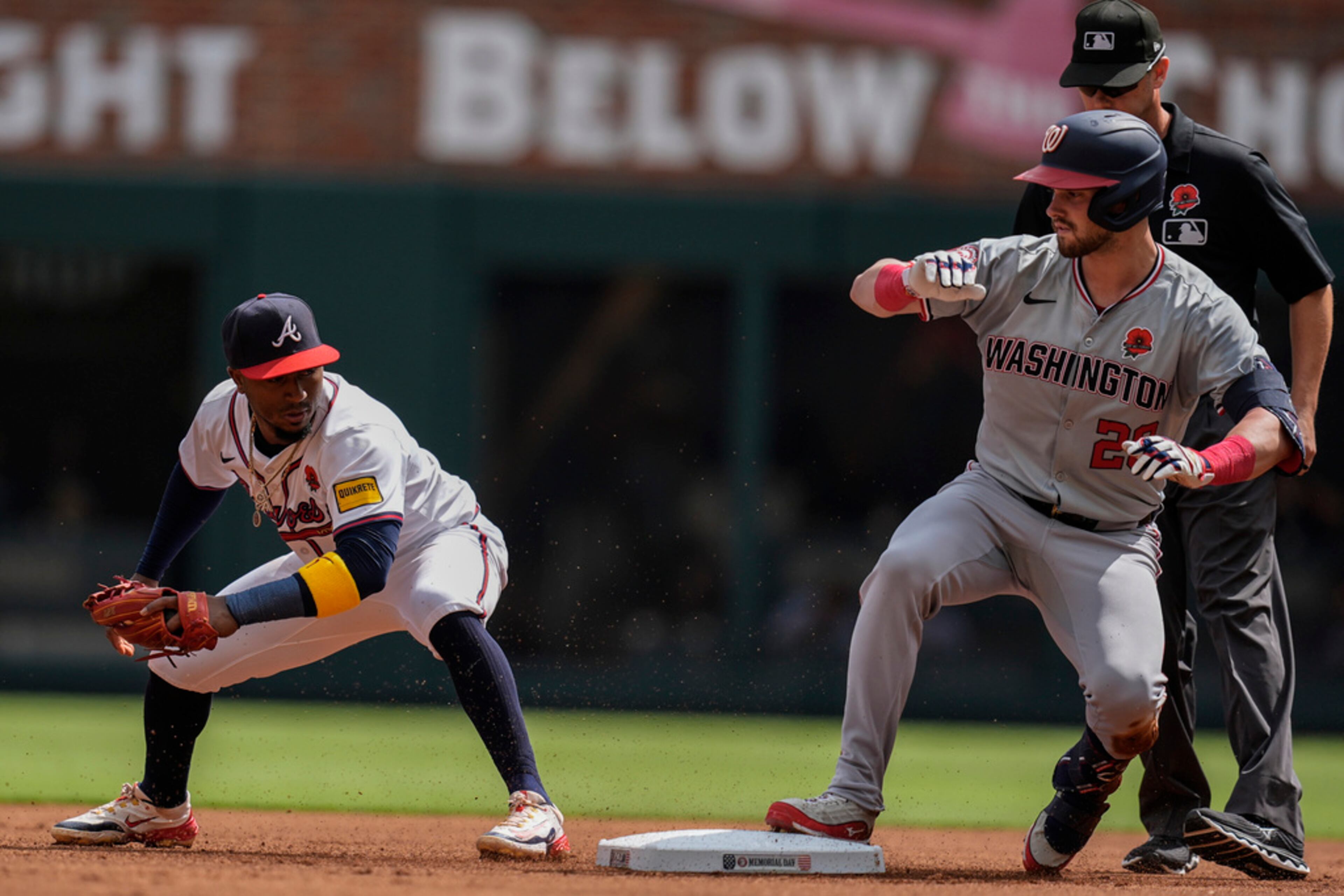 Washington Nationals' Lane Thomas beats the tag at second base by Atlanta Braves shortstop Orlando Arcia (11) in the first inning of a baseball game, Monday, May 27, 2024, in Atlanta. (AP Photo/Mike Stewart)