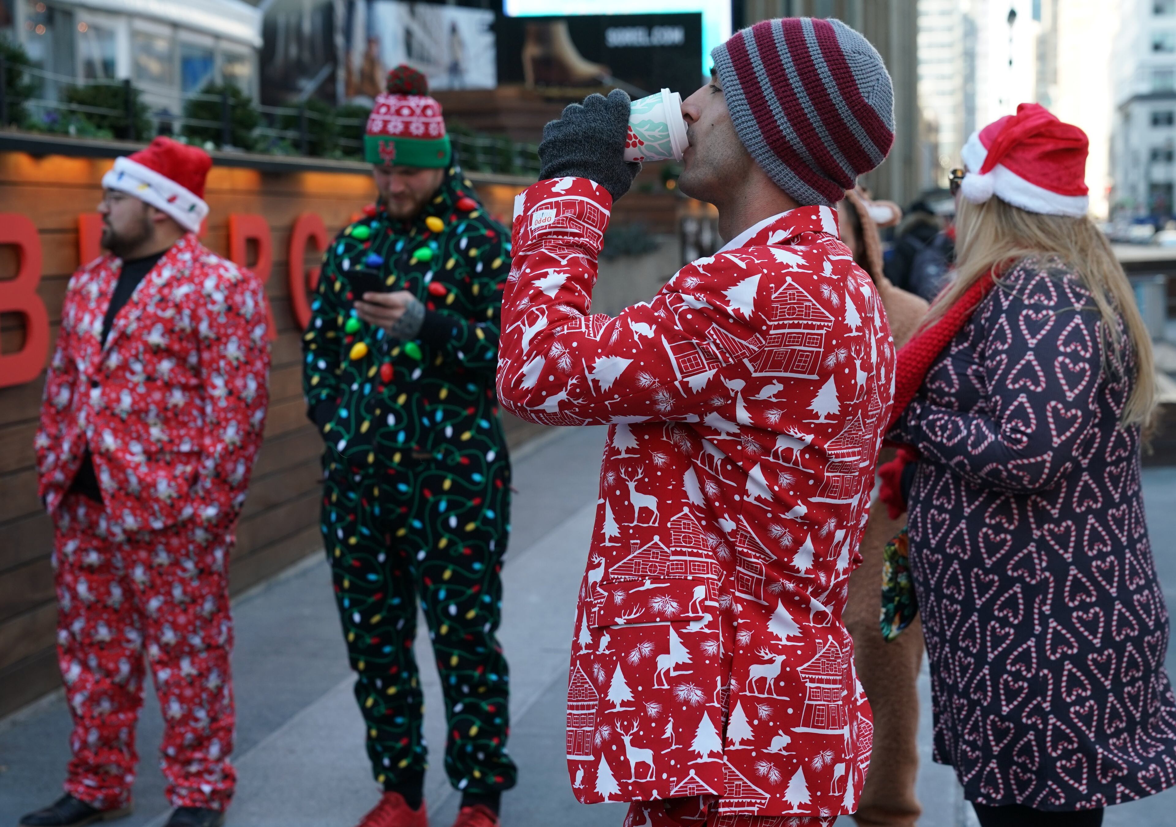 Revelers dressed as Santa Claus or in festive costumes arrive for the start of SantaCon 2018 in New York City December 8, 2018. - SantaCon the official Santa pub crawl happens in bars all across the world. (Photo by TIMOTHY A. CLARY / AFP)