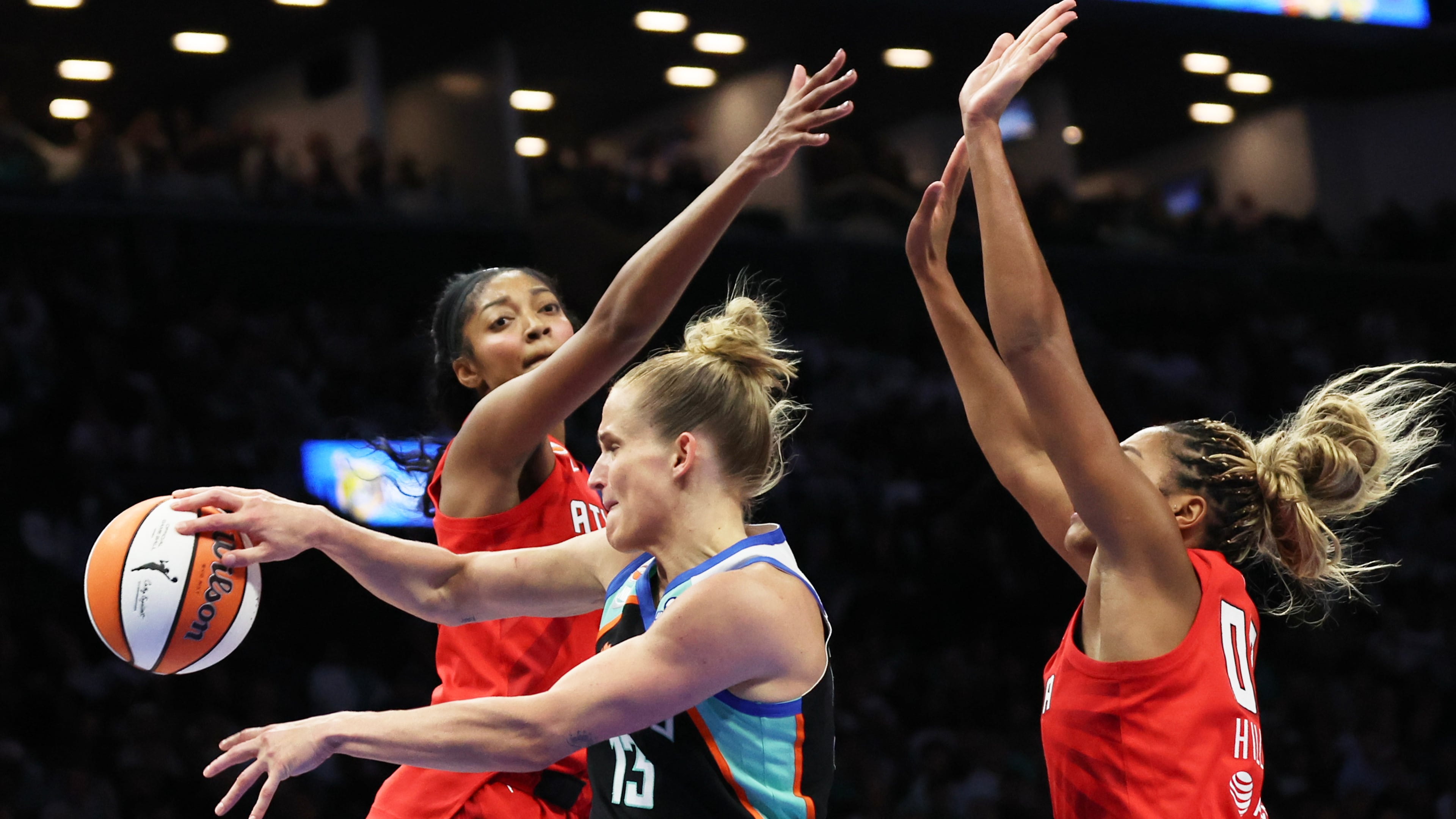 New York Liberty forward Leonie Fiebich, center, passes the ball against Atlanta Dream forwards Angel Reese, left, and Naz Hillmon, right, during the first half of Game 3 of the WNBA basketball semifinals, Friday, Oct. 9, 2026, in New York. (AP Photo/Heather Khalifa)