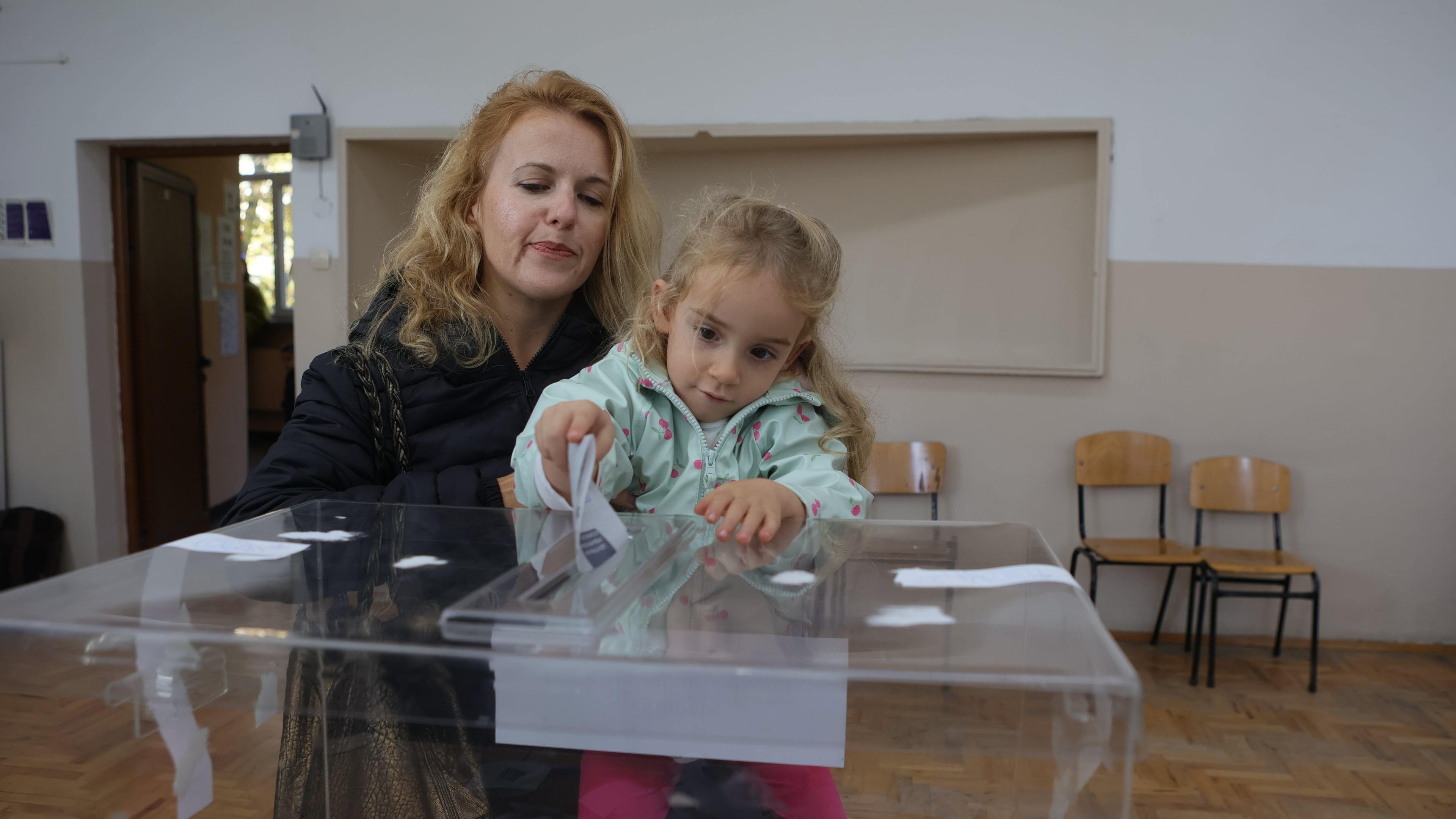 A woman with a child casts her vote in Sofia, Bulgaria, Sunday, Oct. 25, 2026, during the Presidential Election. (AP Photo/ Valentina Petrova)