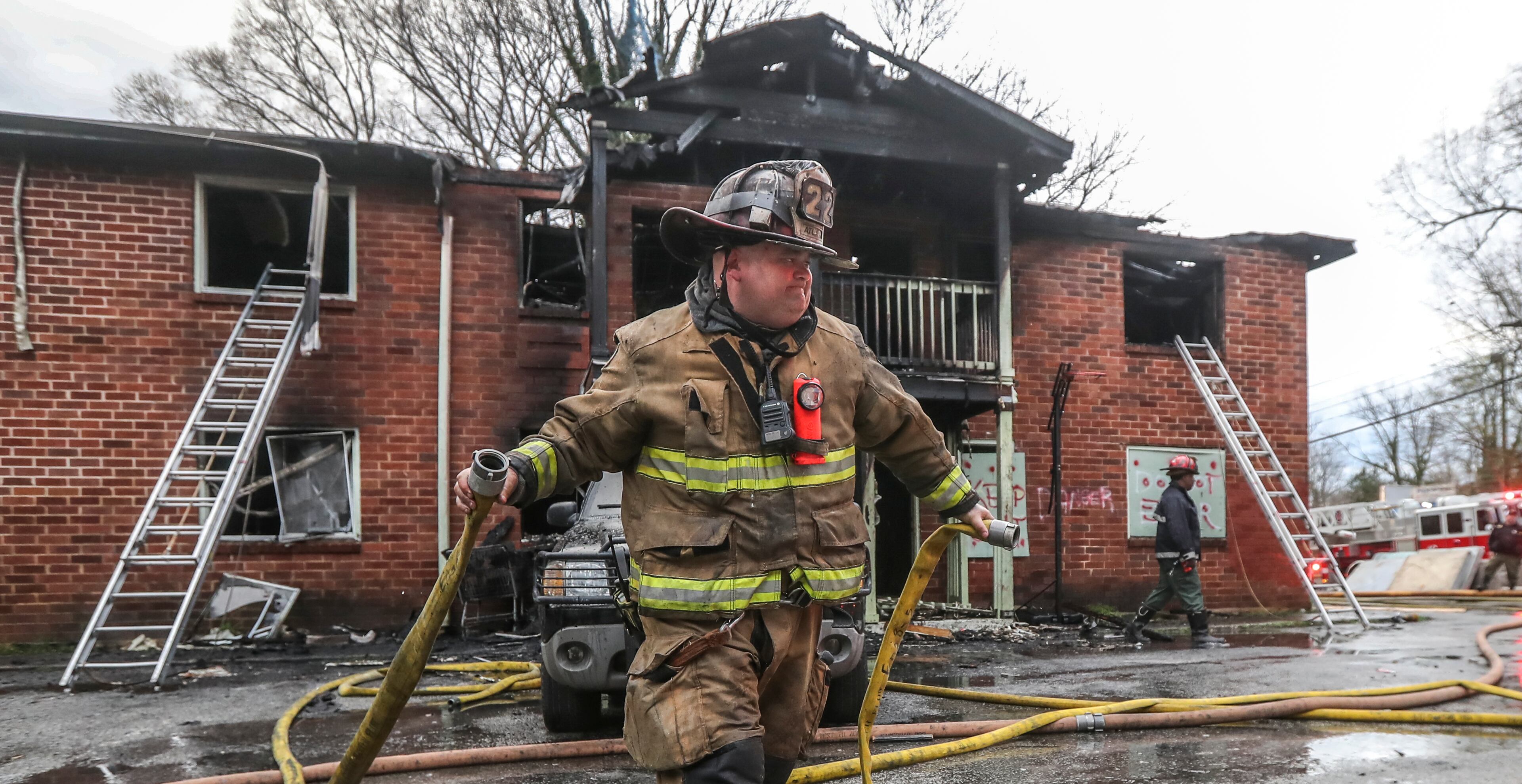 Atlanta firefighter, Matthew Benton of Truck 16 brings in hose at a fire at an apartment building on Joseph E. Boone Boulevard that left one person dead Tuesday morning, March 29, 2022. Another person required treatment for smoke inhalation. (John Spink / John.Spink@ajc.com)