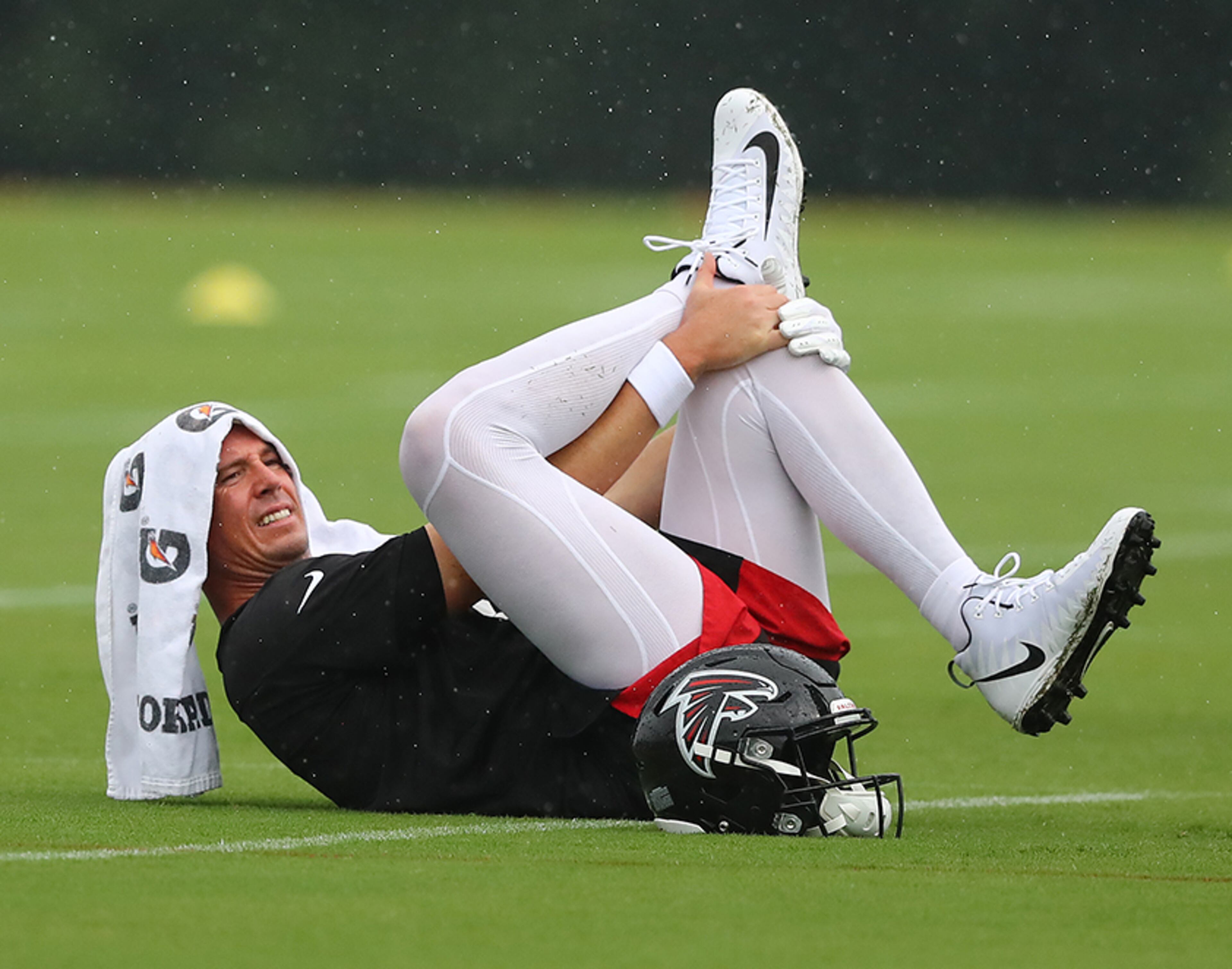 Falcons quarterback Matt Ryan loosens up in the wet field as the team began the second practice of training camp Tuesday, July 23, 2019, in Flowery Branch.