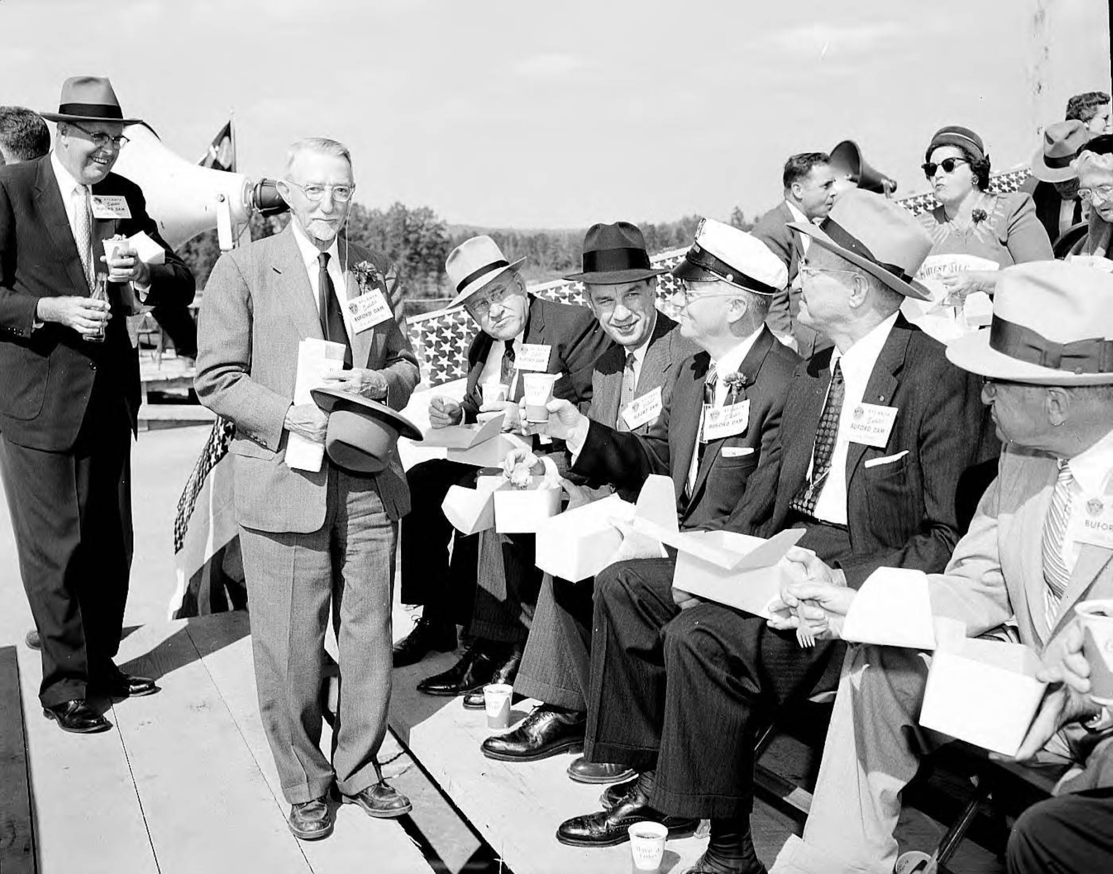 Dignitaries enjoy a box lunch at the Buford Dam dedication in October 1957. LBME1-026f, Lane Brothers Commercial Photographers Photographic Collection, 1920-1976. Photographic Collection, Special Collections and Archives, Georgia State University Library.