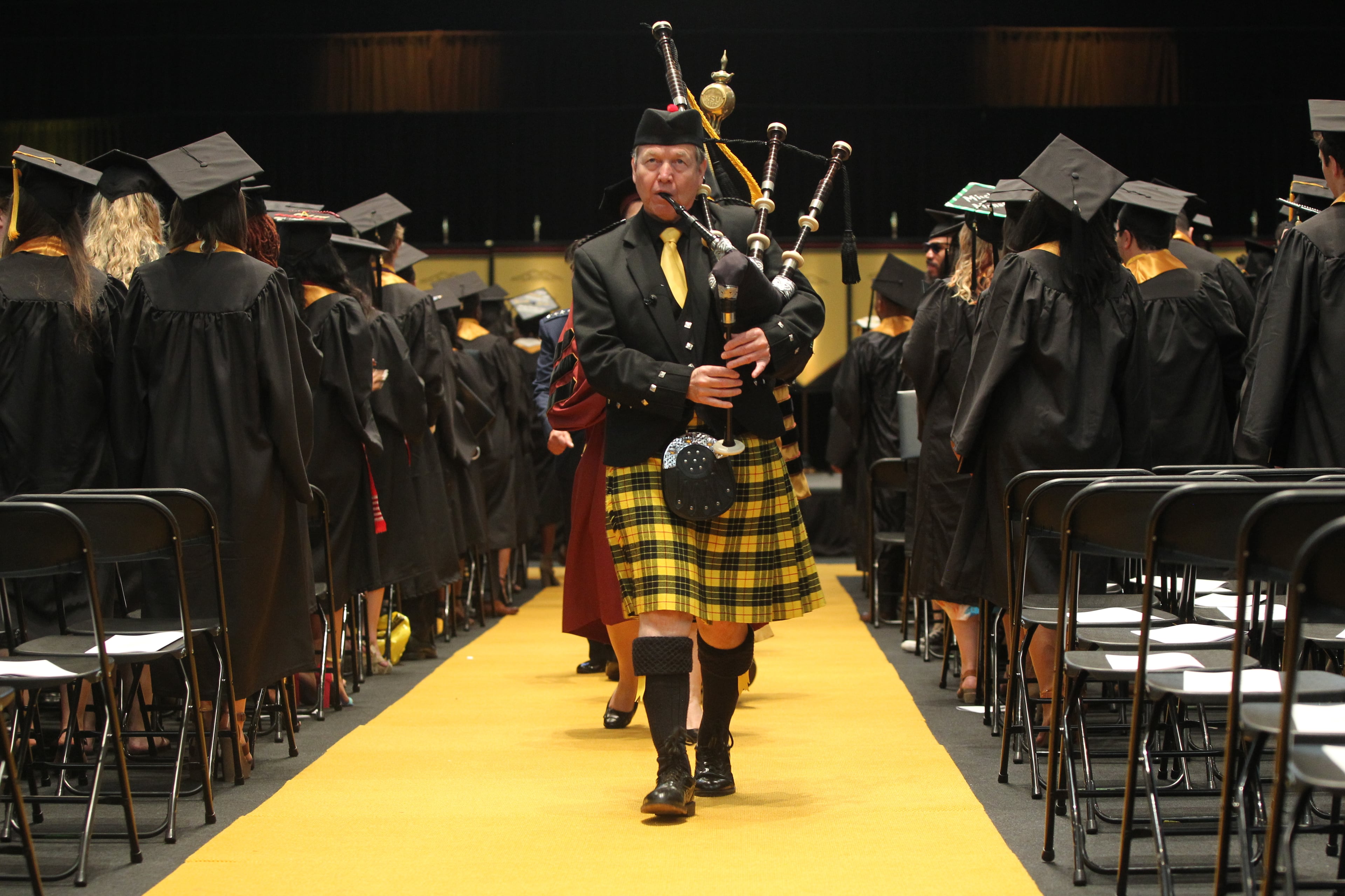 May 10, 2017, Atlanta, Georgia - Students along with their family and friends from Kennesaw State University in the College of Humanities and Social Sciences attend their Commencement ceremony to graduate from the university in Kennesaw, Georgia, on May 10, 2017. The Bagpiper Tom Crawford leads the professors and faculty out after the conclusion of the Commencement Ceremony. (HENRY TAYLOR / HENRY.TAYLOR@AJC.COM)