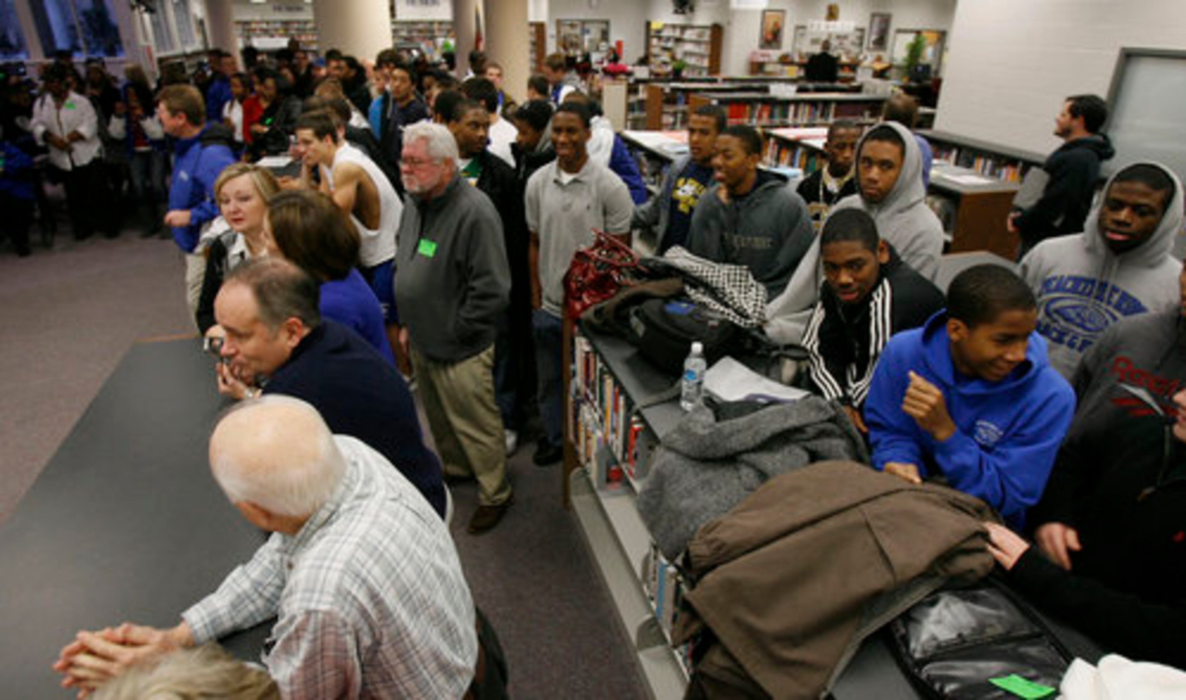 Families, teachers and friends gather as athletes sign their letters of intent with the college of their choice at Peachtree Ridge High in Suwanee.