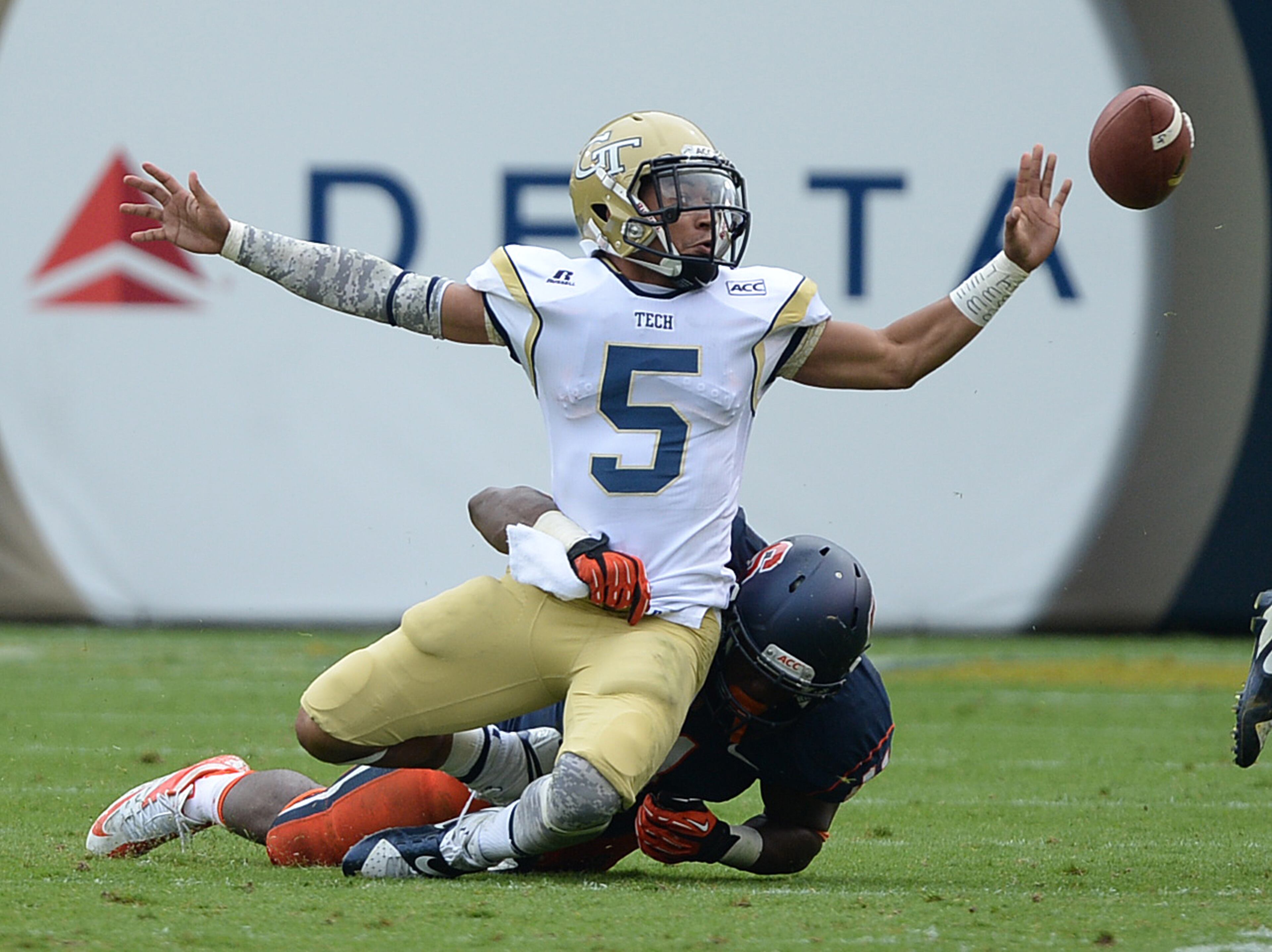 Georgia Tech's quarterback Justin Thomas (5) is hit from behind as he pitches the ball in Bobby Dodd Stadium on Saturday, October 19, 2013. Georgia Tech won the game 56-0.