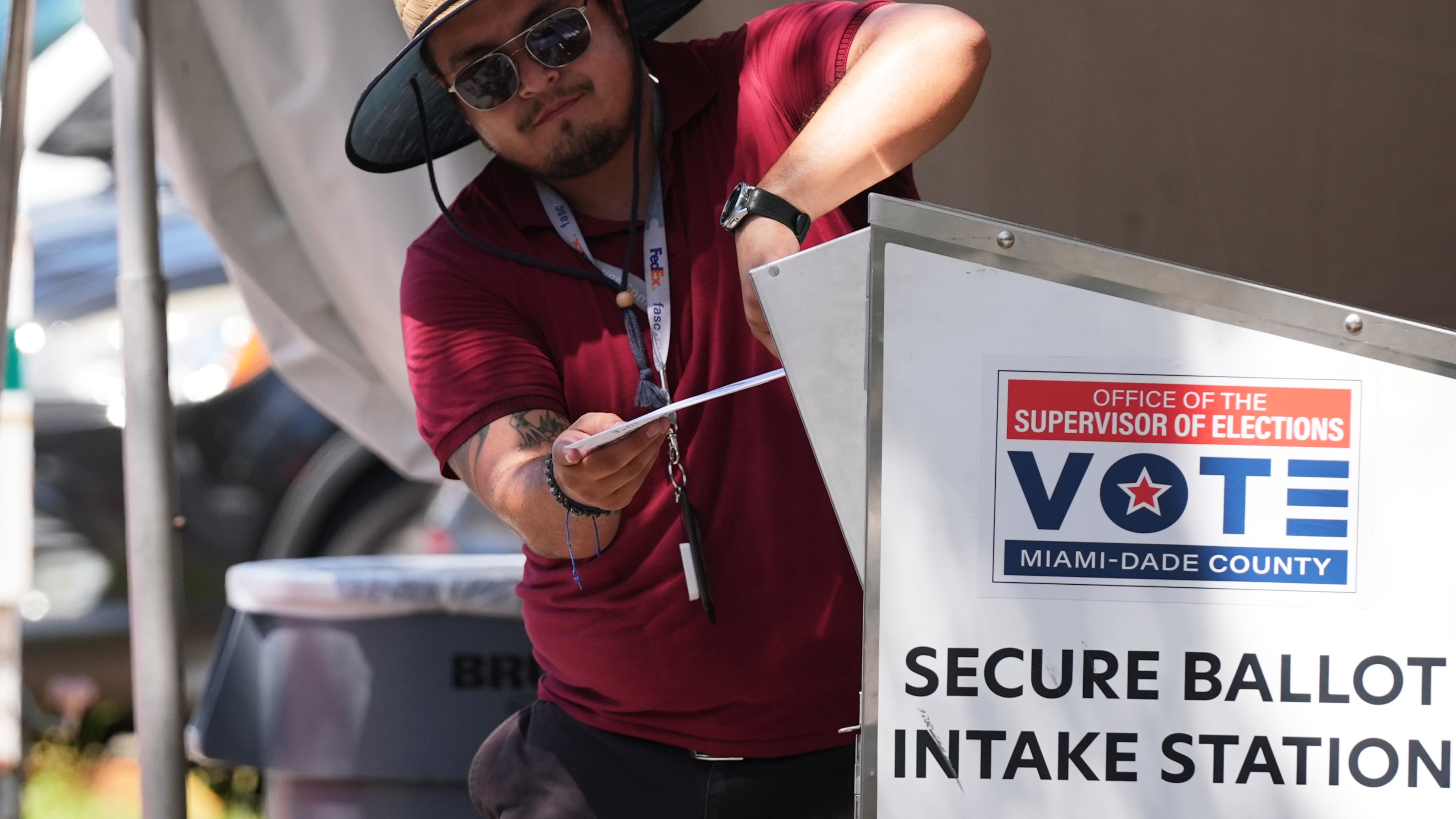 An election worker places a vote-by-mail ballot into a secure bin at the Miami-Dade County Supervisor of Elections Office during the Florida primary election in Doral, Fla., Tuesday, Aug. 18, 2026. (AP Photo/Lynne Sladky)