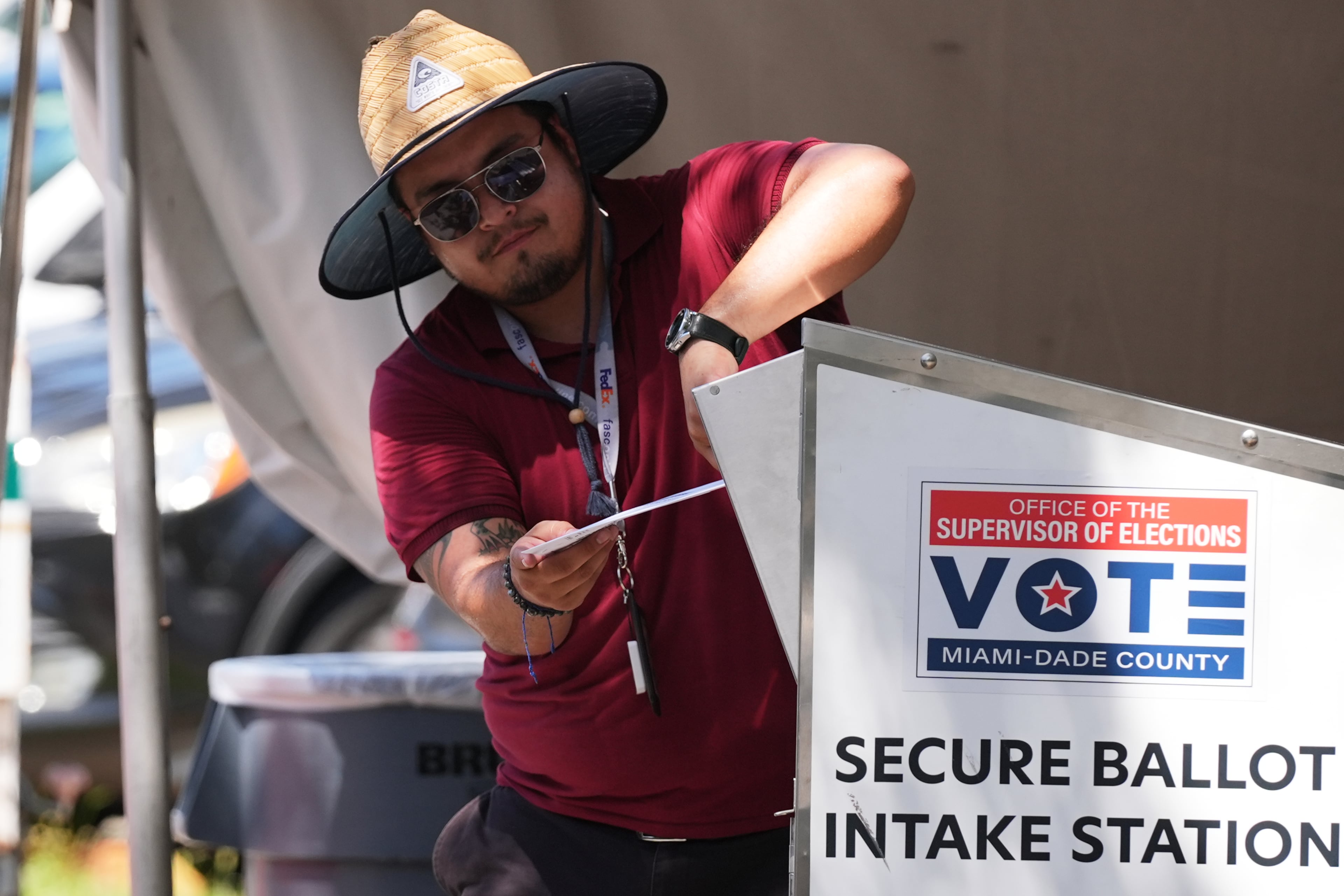 An election worker places a vote-by-mail ballot into a secure bin at the Miami-Dade County Supervisor of Elections Office during the Florida primary election in Doral, Florida, last week. (Lynne Sladky/AP)