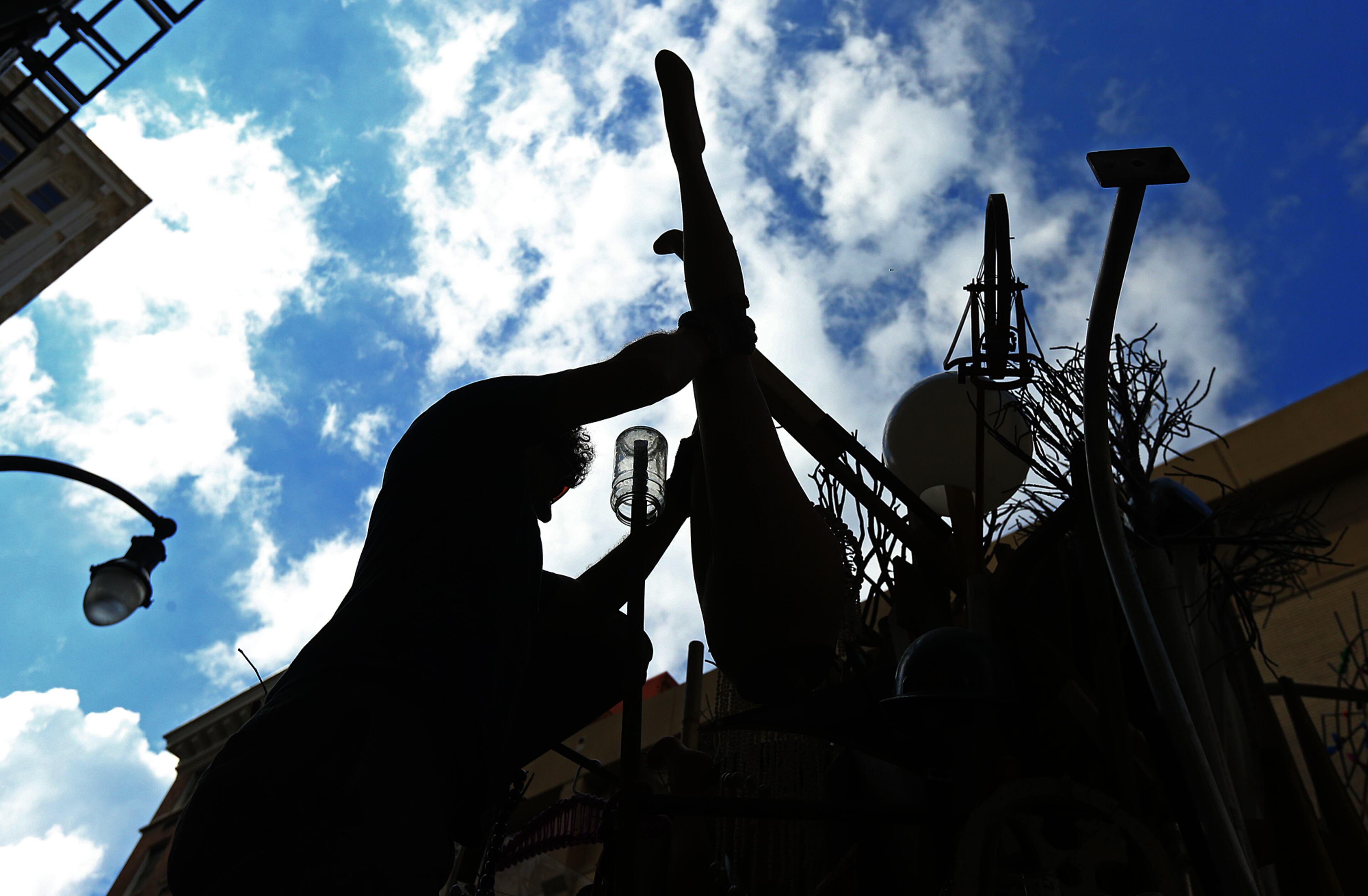 Savannah artist Marcus Kenney adds part of a mannequin to his work while transforming a Dumpster for his art installation "Timeline" Monday, Oct. 13, 2014 on Forsyth Street in Atlanta. 20 artists were given 10 big trash receptacles to create a work of public art that will be part of this year's Elevate, the Office of Cultural Affairs' free week-long public art event from Oct. 17-23. CURTIS COMPTON / CCOMPTON@AJC.COM
