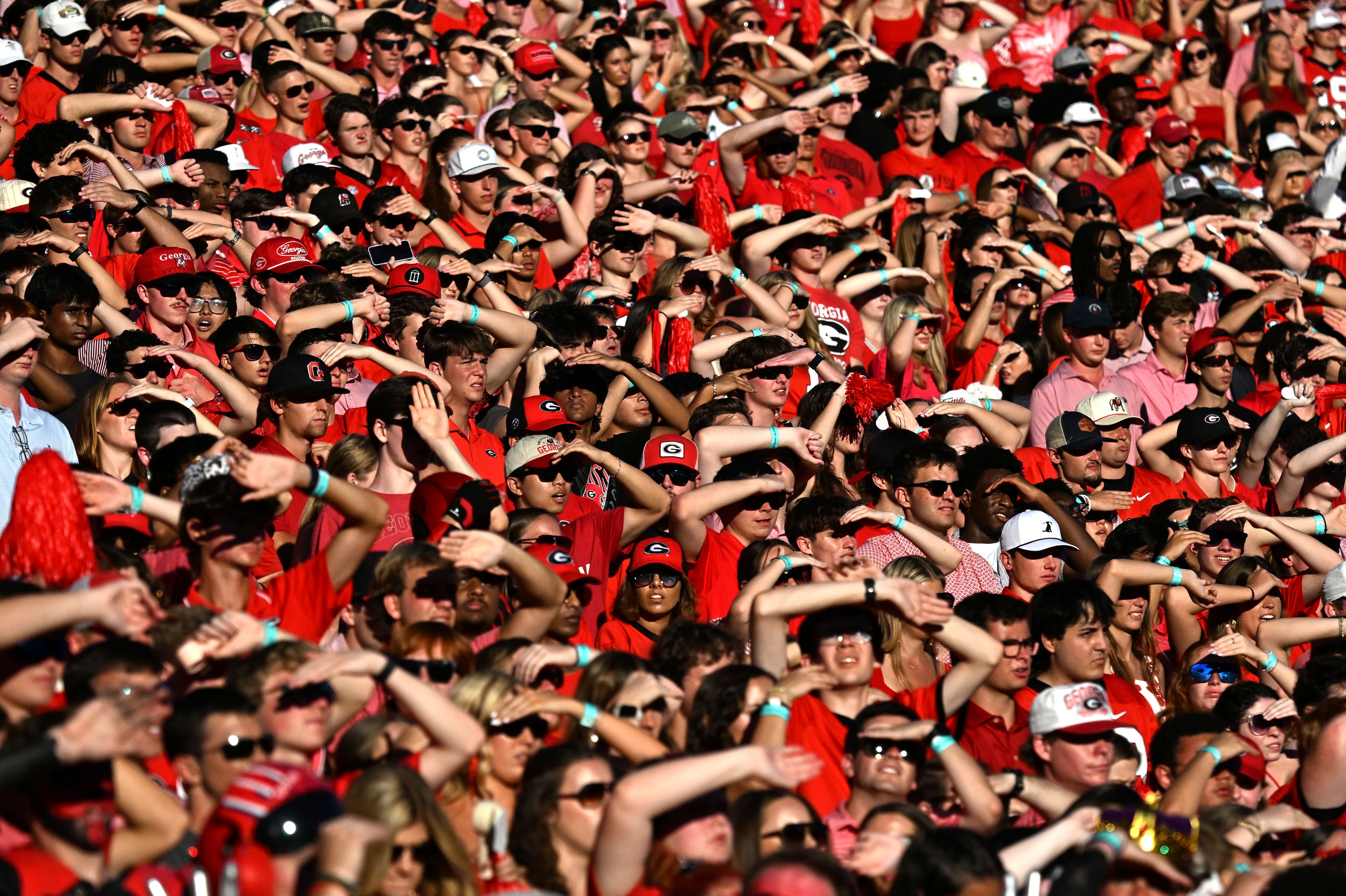 Georgia fans shield themselves from the harsh sunlight during the second half of an NCAA football game against Oklahoma at Sanford Stadium on Saturday, Sept. 26, 2026, in Athens, Ga. Georgia defeated Oklahoma 41-13. (Hyosub Shin/AJC)