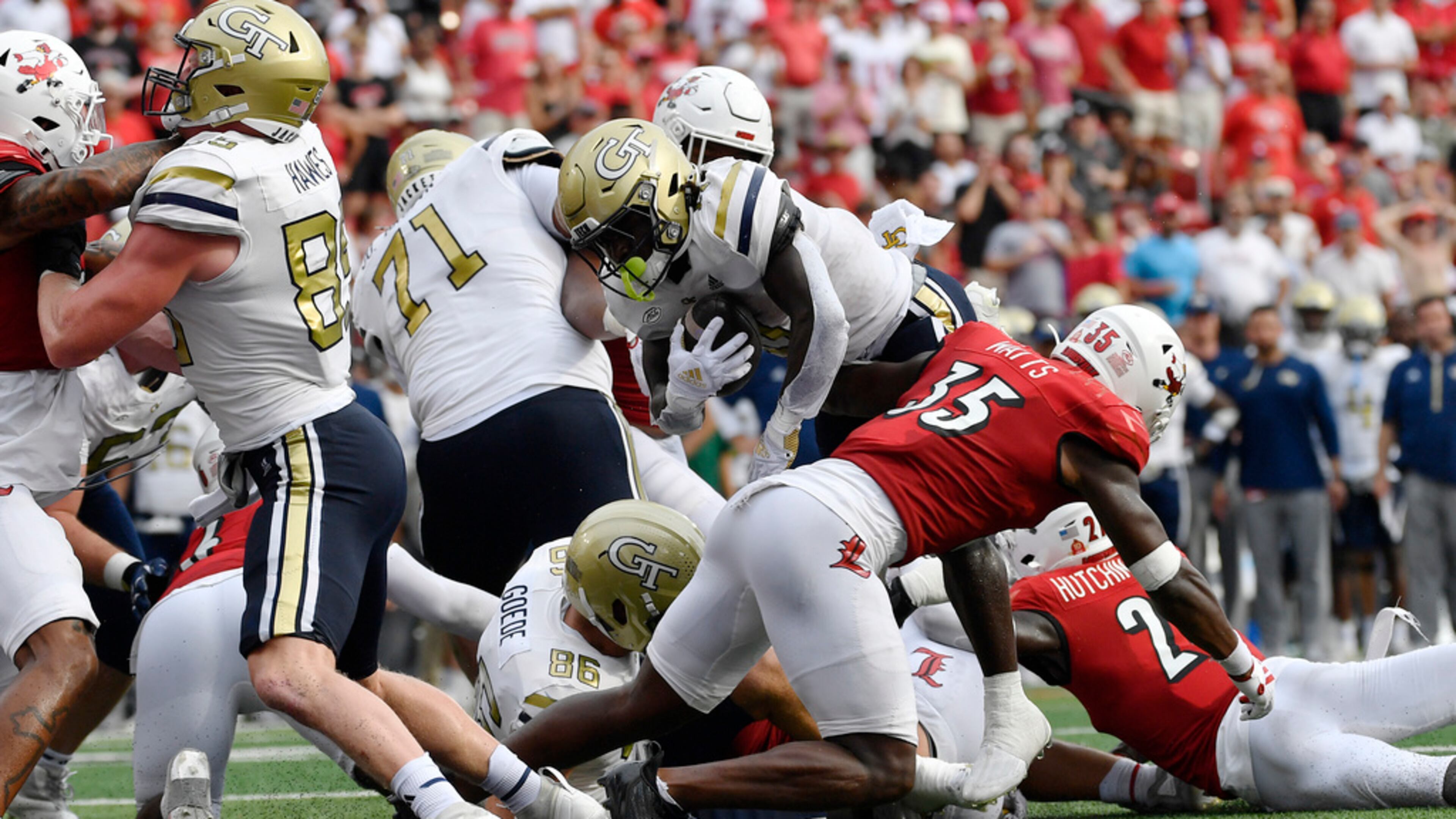 Georgia Tech running back Jamal Haynes, center, leaps over the line past the block of left tackle Jordan Brown (71) to score during the first half of an NCAA college football game in Louisville, Ky., Saturday, Sept. 21, 2024. (AP Photo/Timothy D. Easley)
