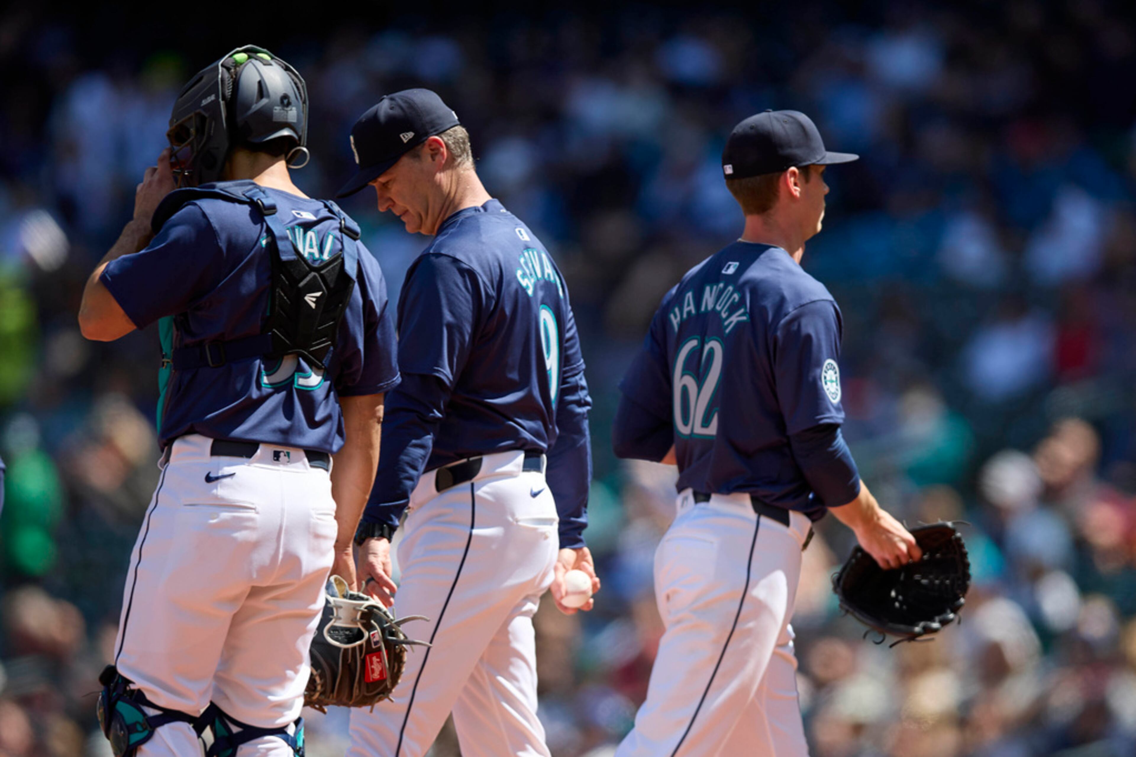 Seattle Mariners starting pitcher Emerson Hancock exits the game, right, with designated hitter Cal Raleigh talking with manager Scott Servais during the fourth inning of a baseball game against the Atlanta Braves, Wednesday, May 1, 2024, in Seattle. (AP Photo/John Froschauer)