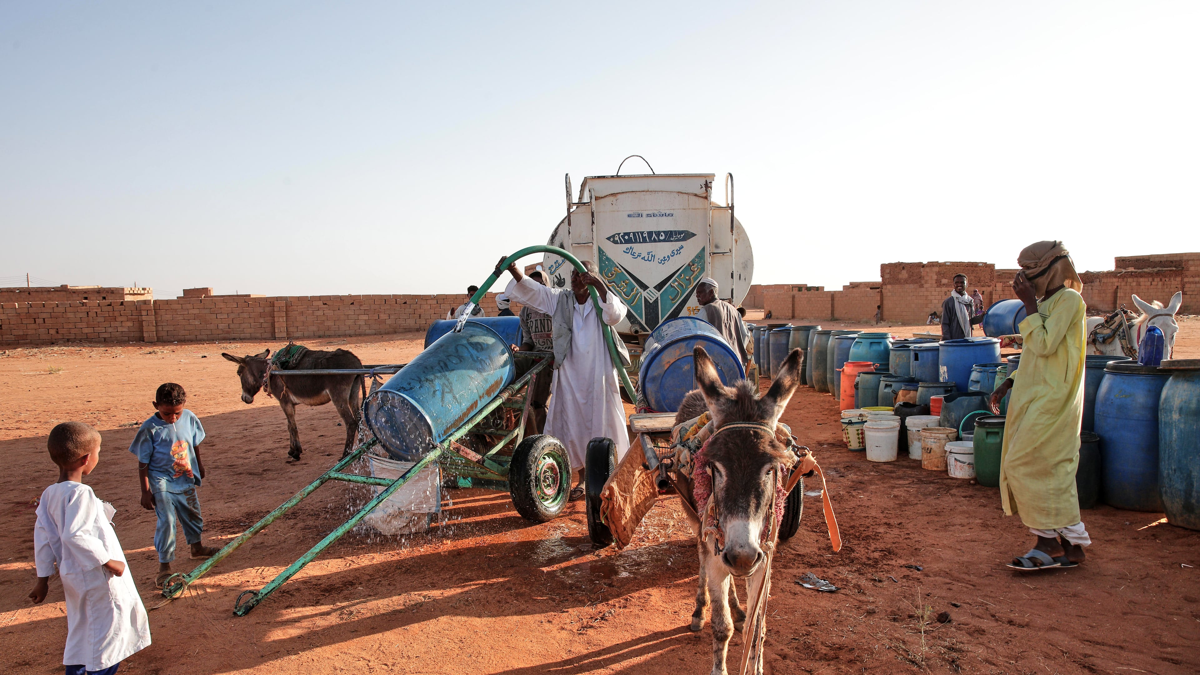 FILE - People fill water containers at a free distribution point due to water outages in Khartoum, Sudan, on Jan. 30, 2026. (AP Photo/Marwan Ali, File)