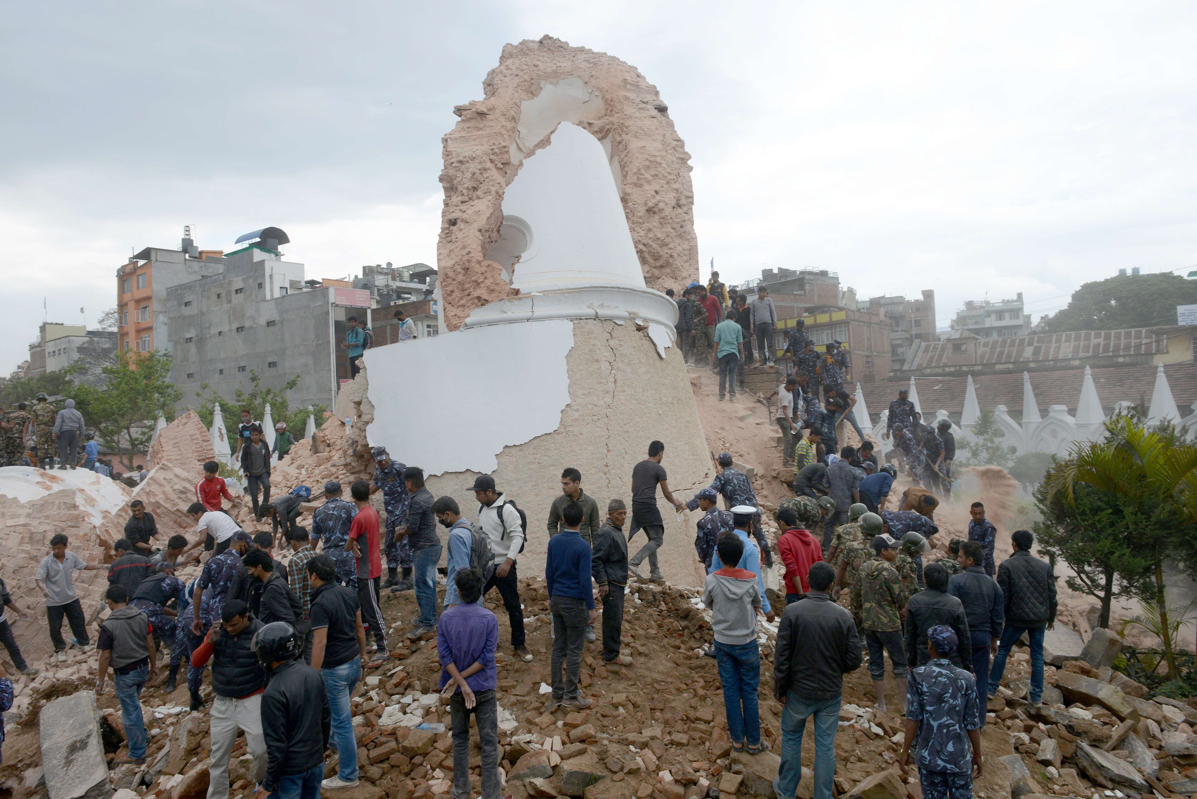 Nepalese rescue members and onlookers gather at the collapsed Darahara Tower in Kathmandu on April 25, 2015. A powerful 7.9 magnitude earthquake struck Nepal, causing massive damage in the capital Kathmandu with strong tremors felt across neighbouring countries. AFP PHOTO / PRAKASH MATHEMA (Photo credit should read PRAKASH MATHEMA/AFP/Getty Images)