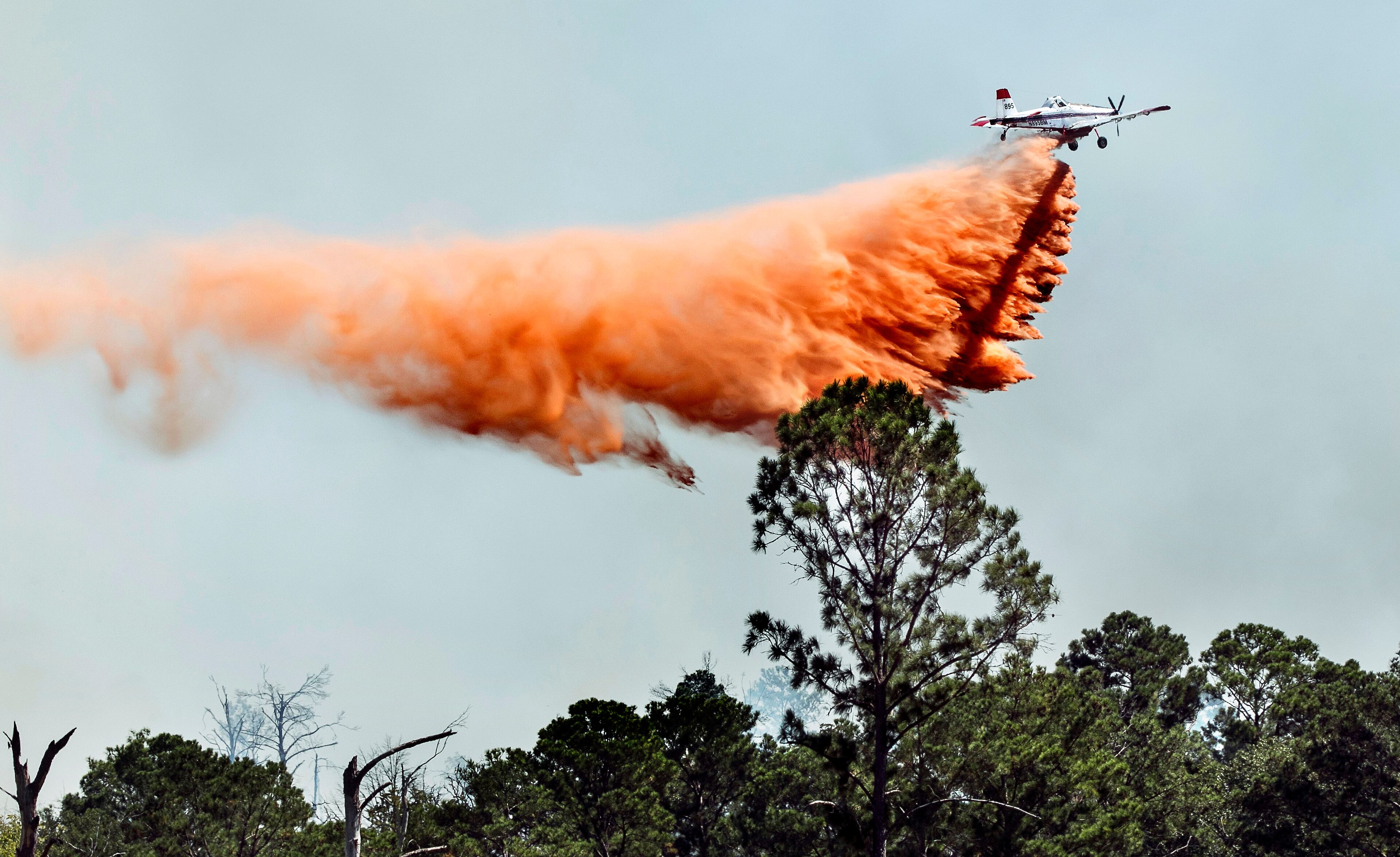 A single engine air tanker, S.E.A.T., drops fire retardant material onto the Hidden Pines Fire near Autumn Creek Road and Park Road 1C near Smithville, Texas, on Thursday, October 15, 2015.