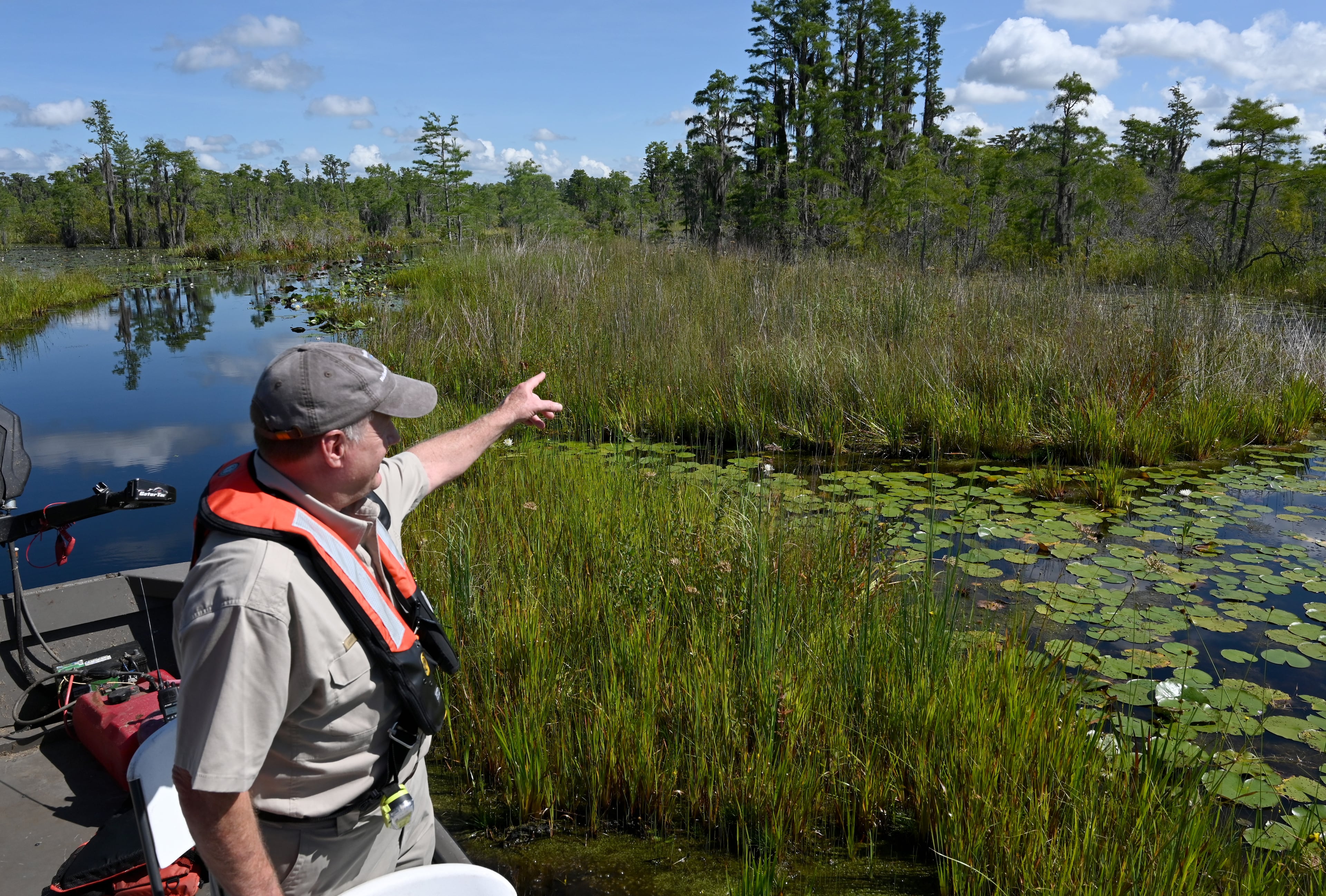 Larry Woodward, deputy refuge manager of the Okefenokee National Wildlife Refuge, points across a flooded prairie in the Okefenokee Swamp on Tuesday, Aug. 12, 2025. (Hyosub Shin/AJC)