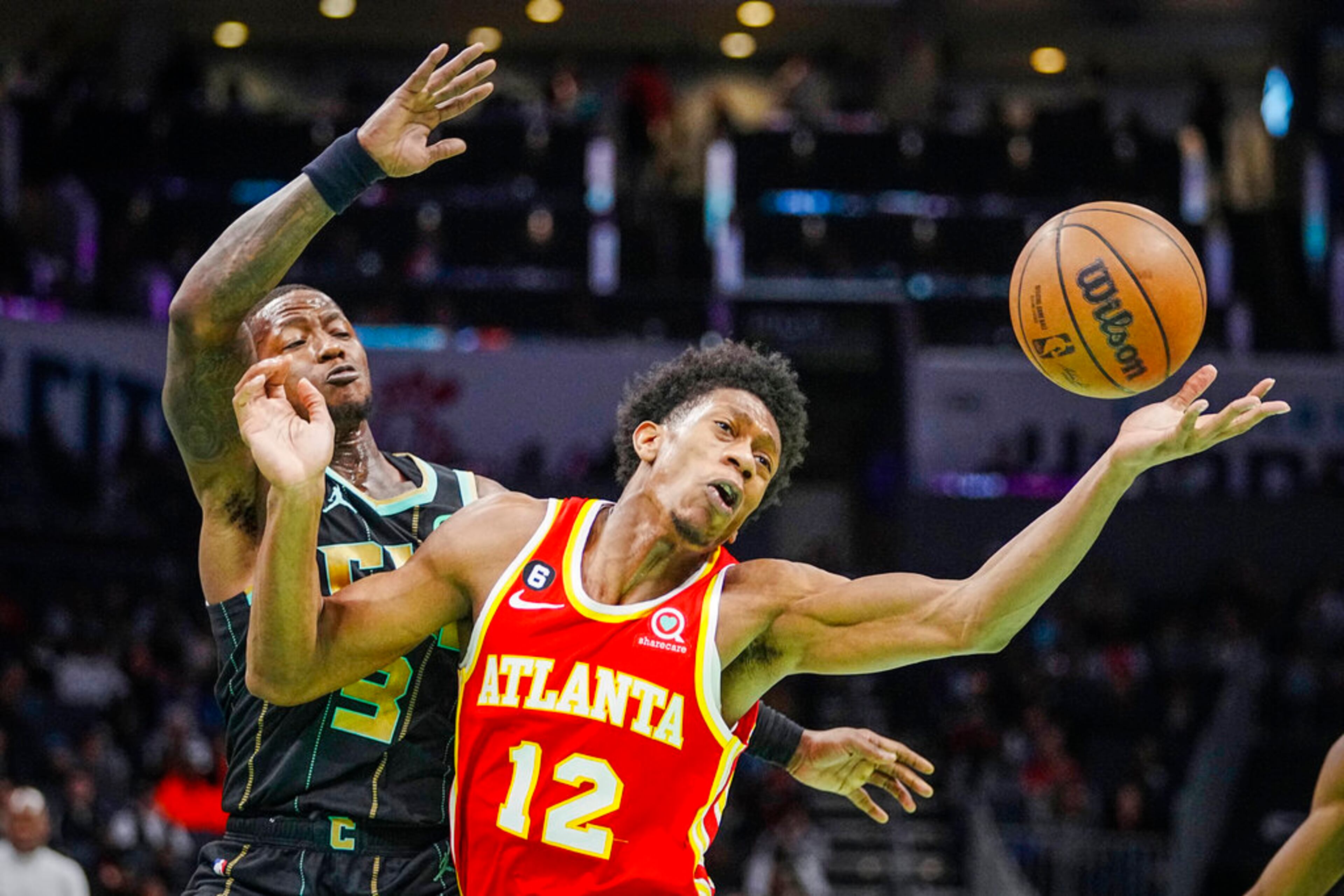 Atlanta Hawks forward De'Andre Hunter (12) loses the ball under the defense of Charlotte Hornets guard Terry Rozier (3) during the second half of an NBA basketball game Friday, Dec. 16, 2022, in Charlotte, N.C. (AP Photo/Rusty Jones)