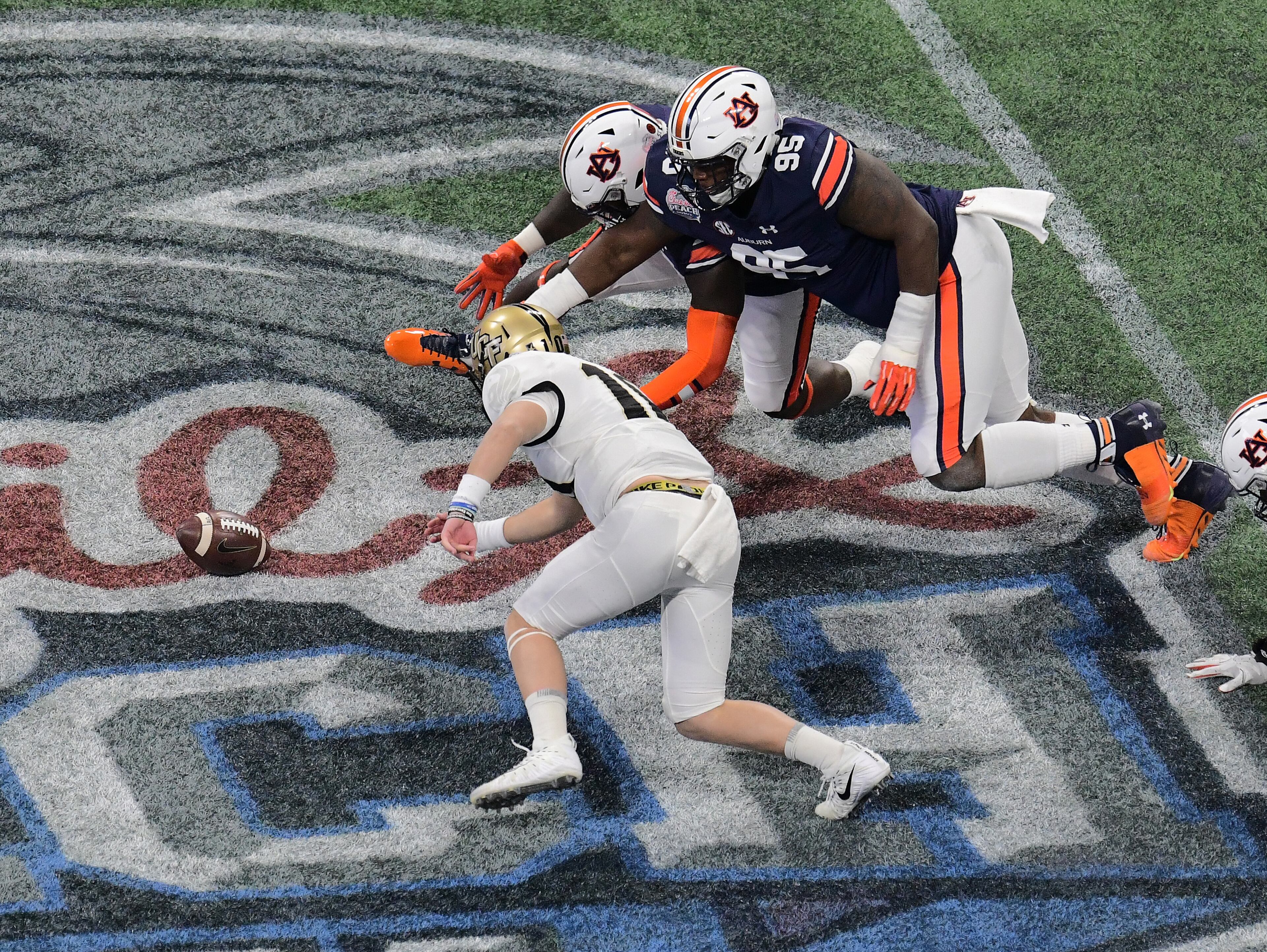 ATLANTA, GA - JANUARY 1: Dontavious Russell #95 and Andrew Williams #79 of the Auburn Tigers pursue a fumble by McKenzie Milton #10 of the Central Florida Knights during the Chick-fil-A Peach Bowl on January 1, 2018 in Atlanta, Georgia. (Photo by Scott Cunningham/Getty Images)