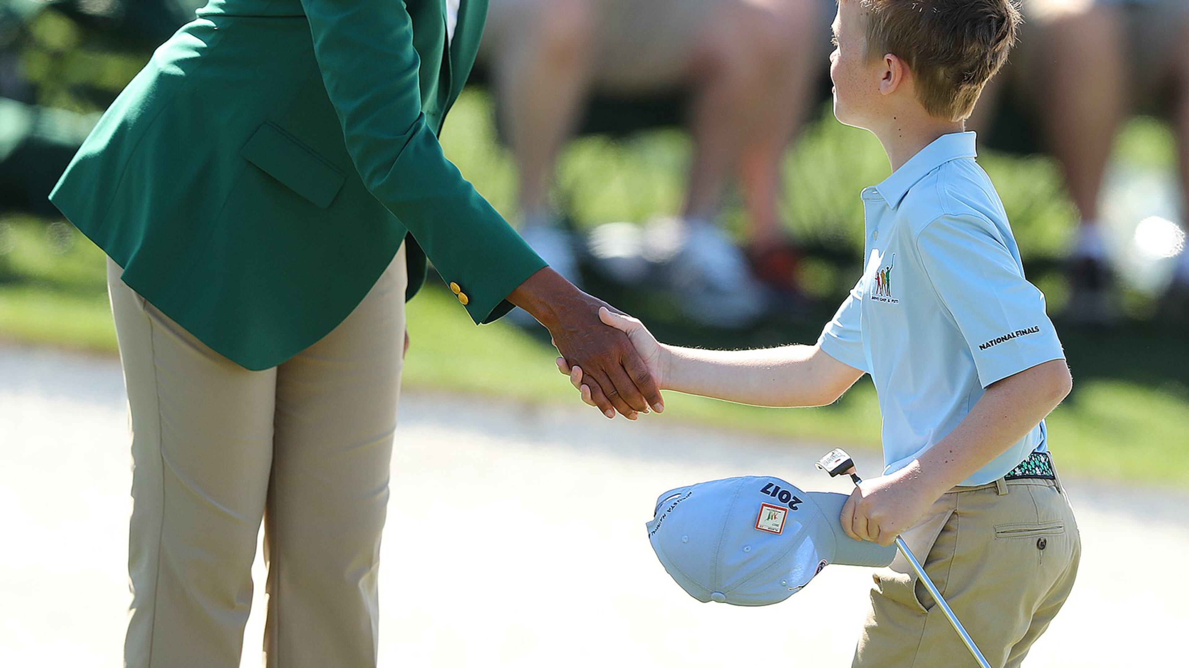 Carter Kontur, of Lawrenceville, is greeted by former Secretary of State (and Augusta National Golf Club member) Condoleezza Rice after putting on the 18th green during the Drive Chip & Putt National Finals at Augusta National Golf Club on Sunday, April 2. (Curtis Compton/ccompton@ajc.com)