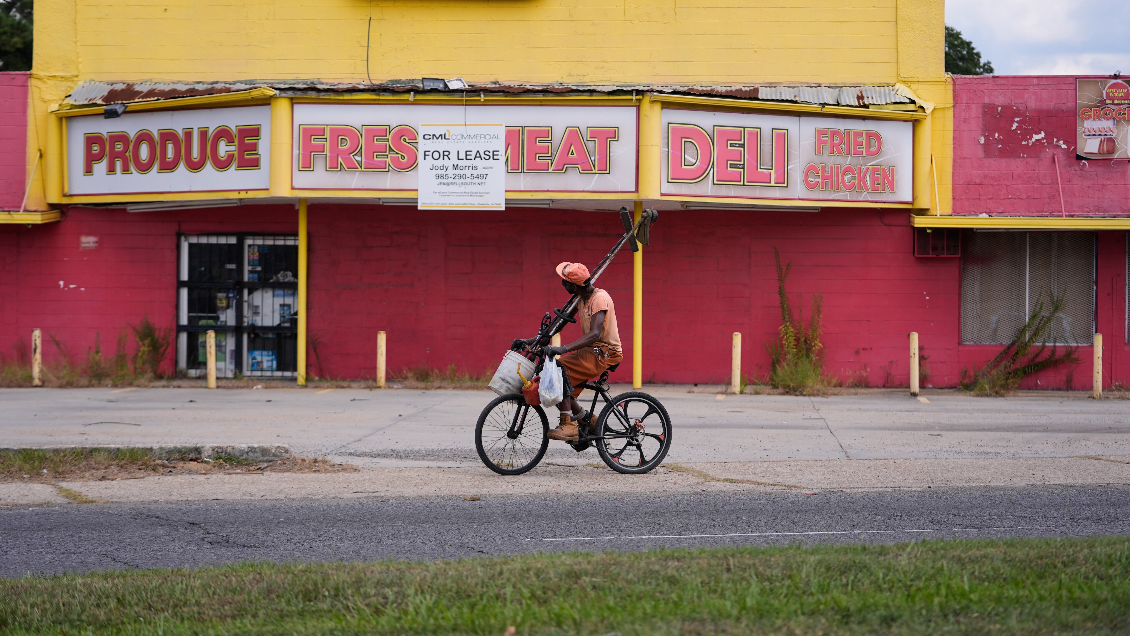 A man rides his bicycle past a closed meat market in the Scotlandville section of Baton Rouge, La., Wednesday, Sept. 16, 2026. (AP Photo/Gerald Herbert)