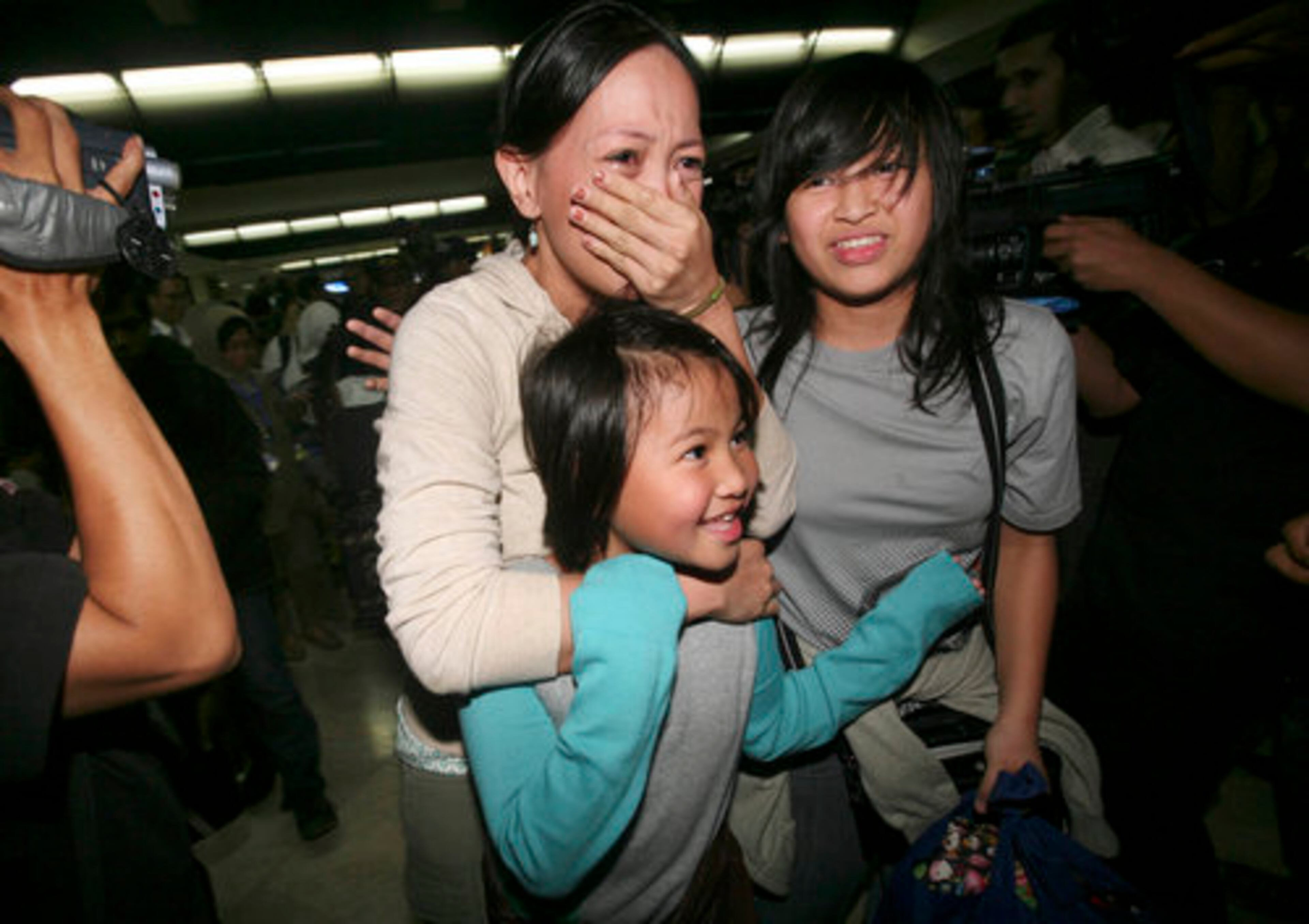 Indonesian family members, part of the Indonesian citizen group evacuated from Japan, are overcome by emotion upon arrival at Soekarno-Hatta International Airport in Jakarta, Indonesia, Tuesday, March 15, 2011.