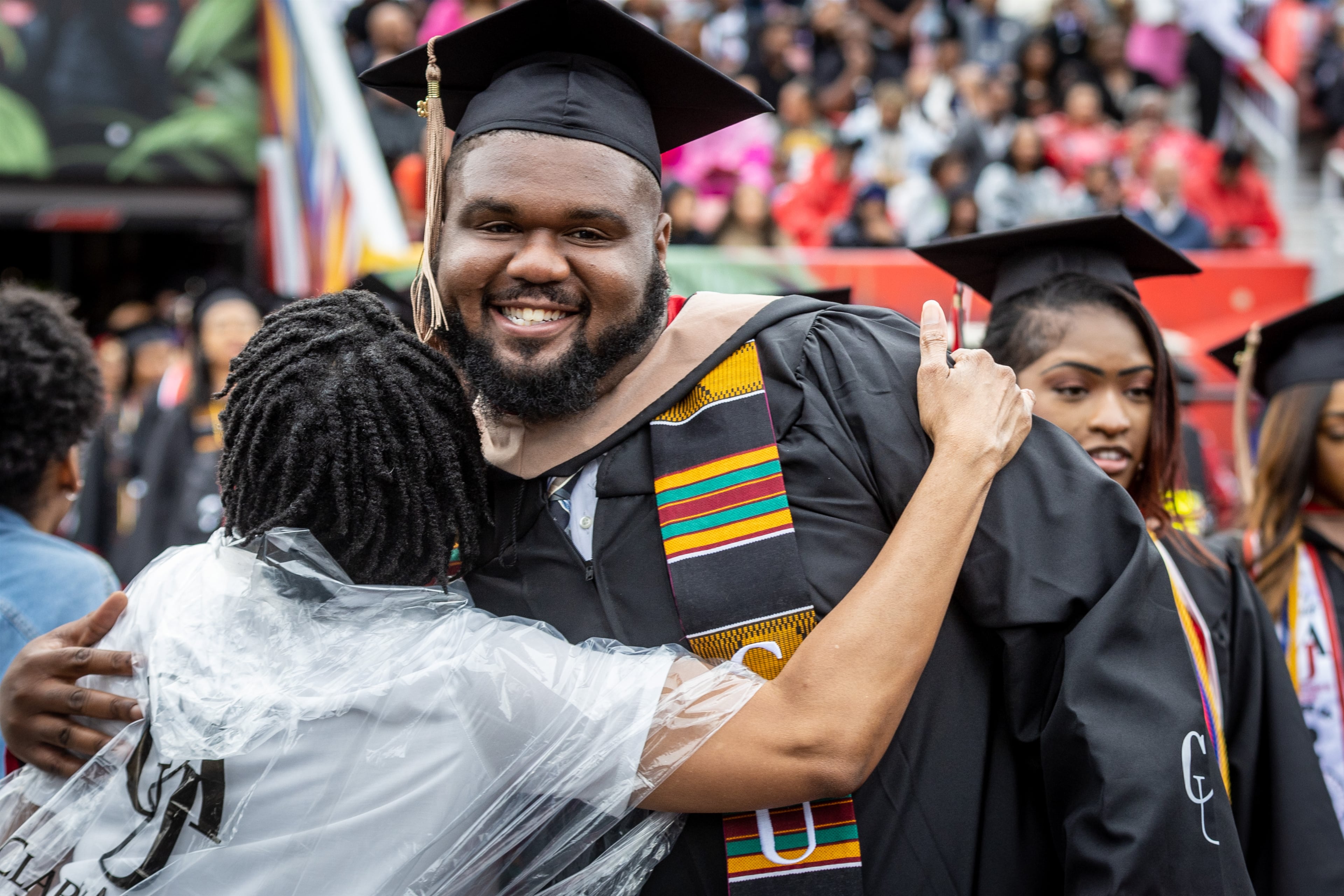 Rae Warner (left) hugs graduates as they enter Panther Stadium for the Clark Atlanta University commencement ceremonies Saturday, May 20, 2023. (Steve Schaefer / steve.schaefer@ajc.com)