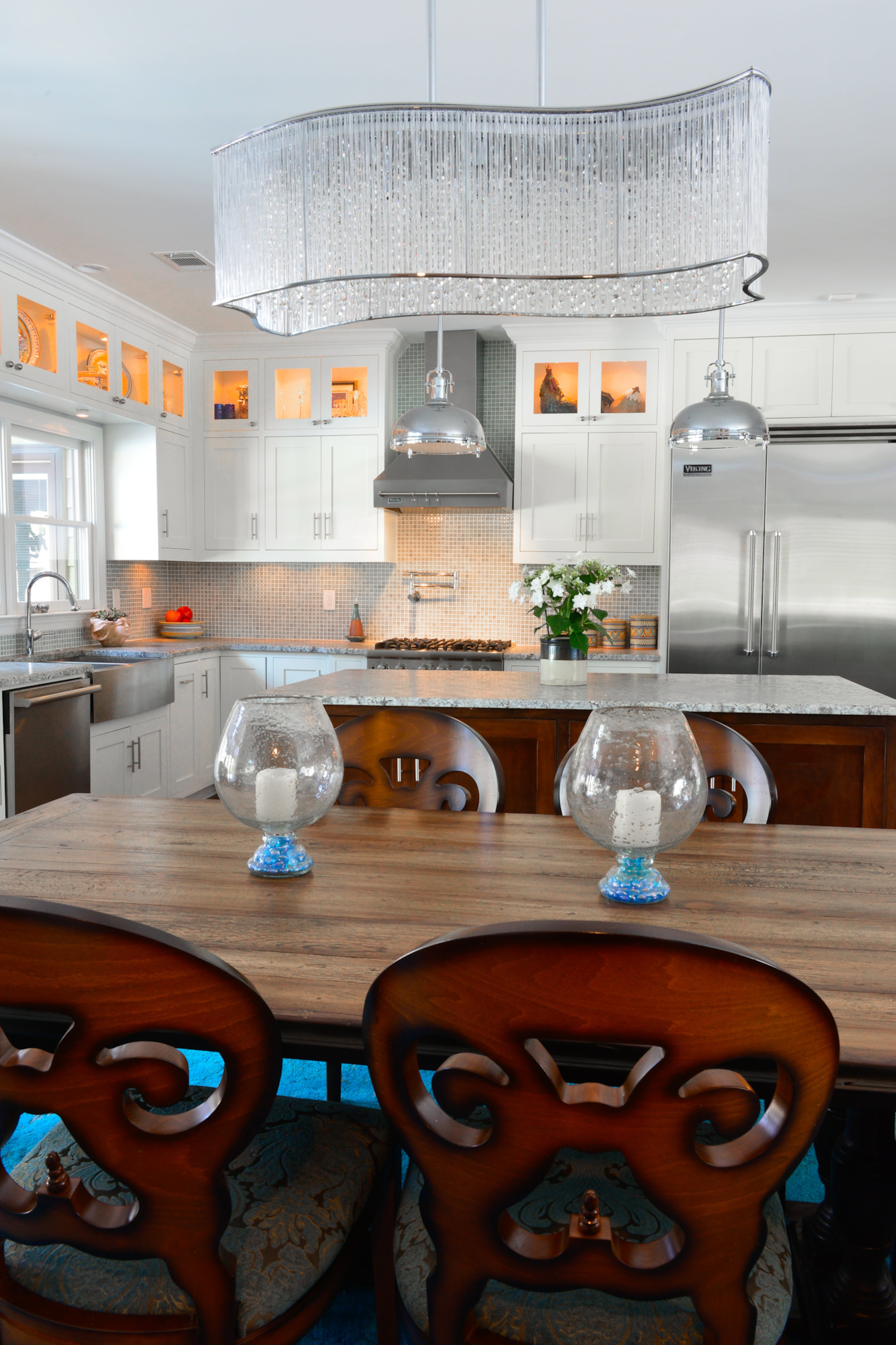 The dining room table was a recent purchase and is the homeowners' favorite new piece of furniture because it mixes distressed details with a modern look, said homeowner Michael Bush. The stainless steel and chrome light fixture over the table is from LUX Lighting in Duluth and is their favorite one in the home.