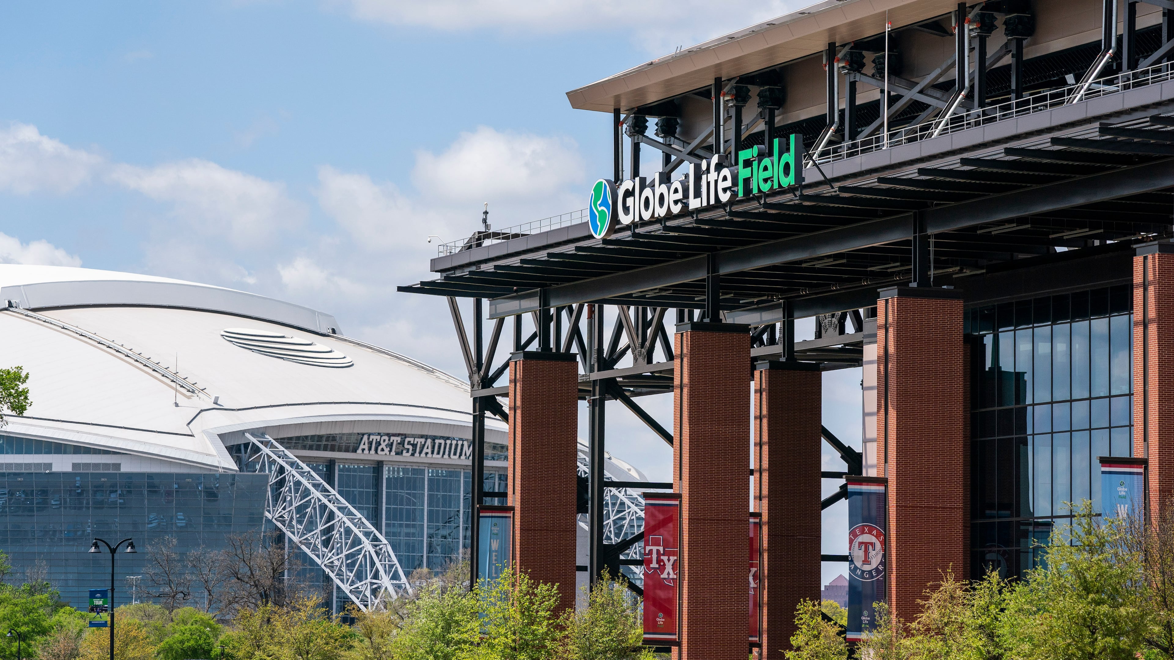 FILE - The facade of Globe Life Field stands in front of the Dallas Cowboys' AT&T Stadium before a baseball game between the Texas Rangers and the Toronto Blue Jays, April 5, 2021, in Arlington, Texas. (AP Photo/Jeffrey McWhorter, File)