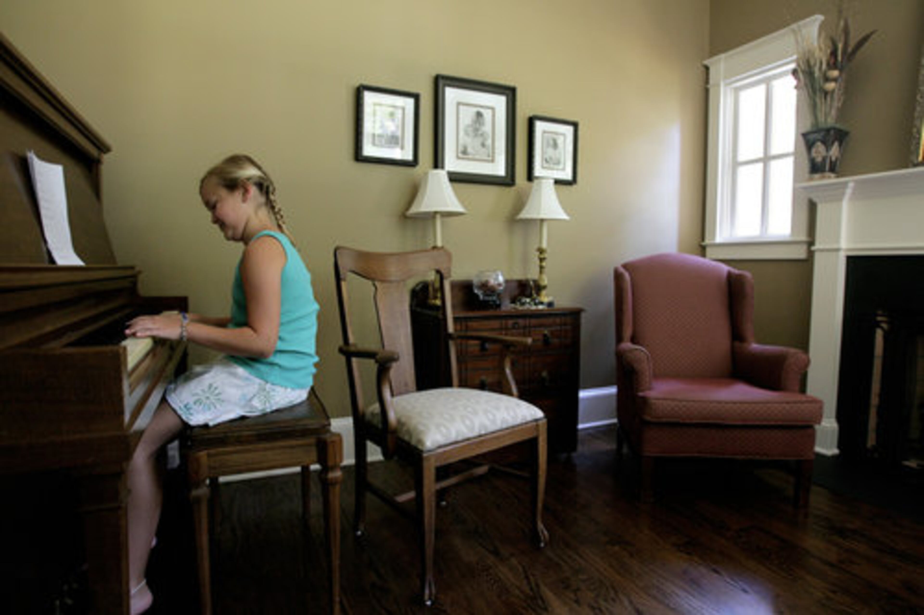 Mackenzie plays piano in the music parlor.