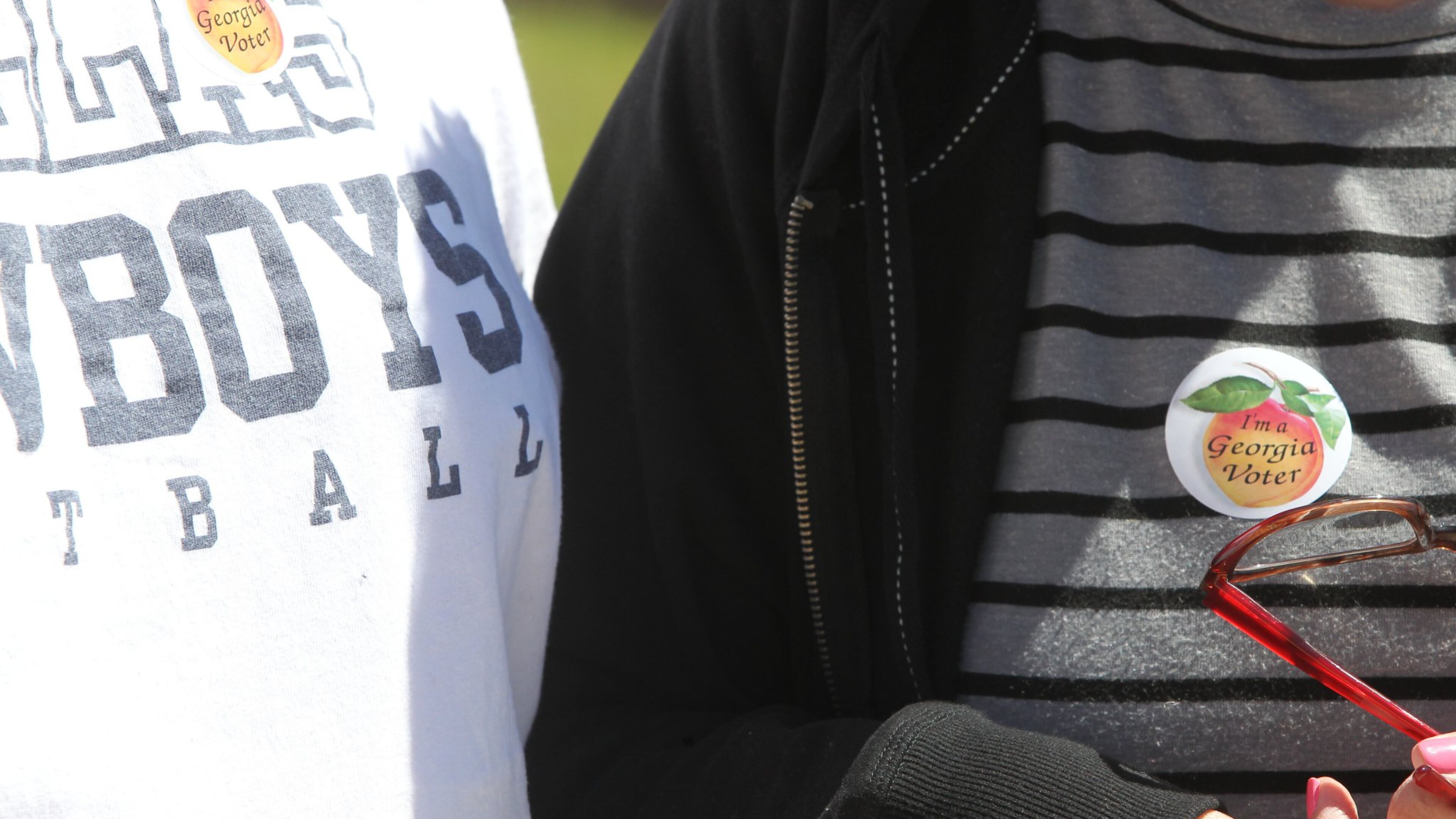 Voters brandish the stickers they are distributed after having voted in any election in the state of Georgia after casting their vote in the 6th District special election to replace Tom Price in Marietta, Georgia, on April 10, 2017. (HENRY TAYLOR / HENRY.TAYLOR@AJC.COM)