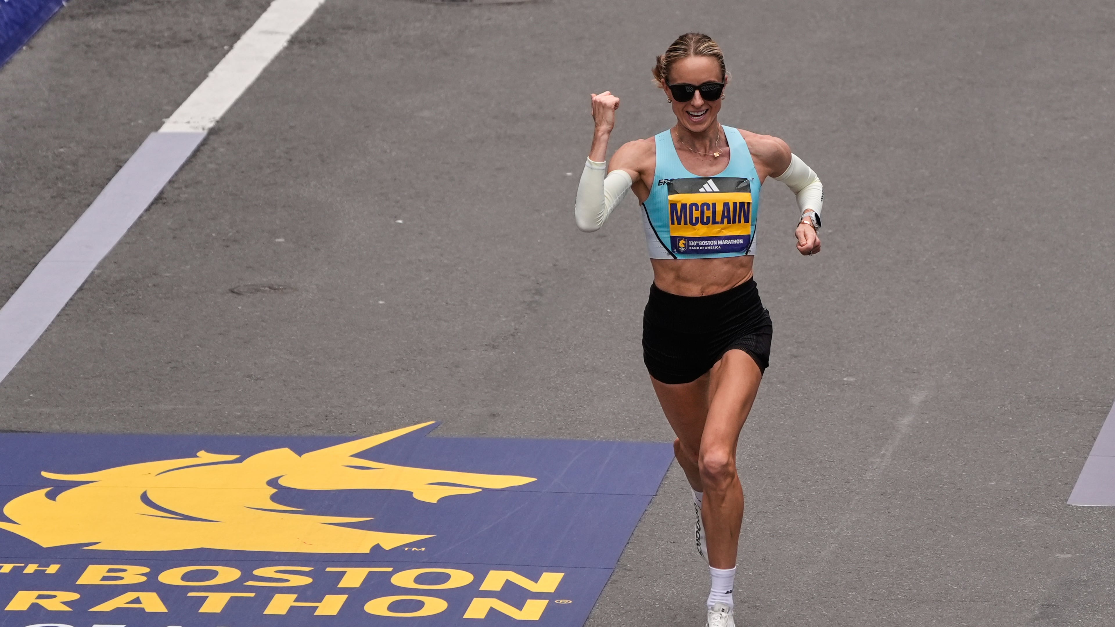 Jess McClain of Phoenix, the top American woman finisher, pumps her fist while approaching the finish line of the Boston Marathon, Monday, April 20, 2026, in Boston. (AP Photo/Charles Krupa)