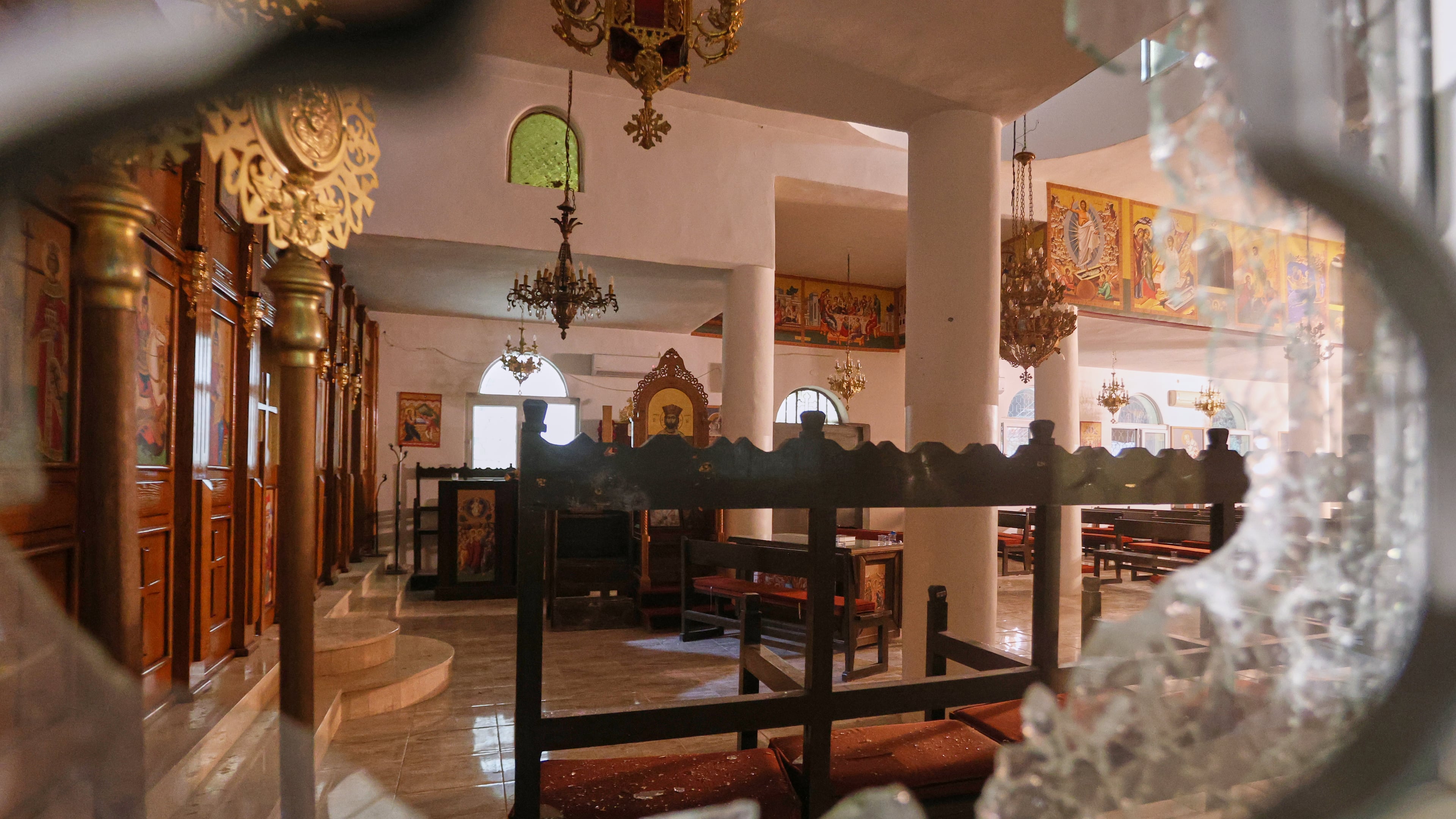 The interior of a Greek Orthodox church is seen through a shattered window hours after gunmen opened fire during a funeral, in Hamoud village, in Jordan's Karak governorate, Friday, Oct. 23, 2026. (AP Photo)