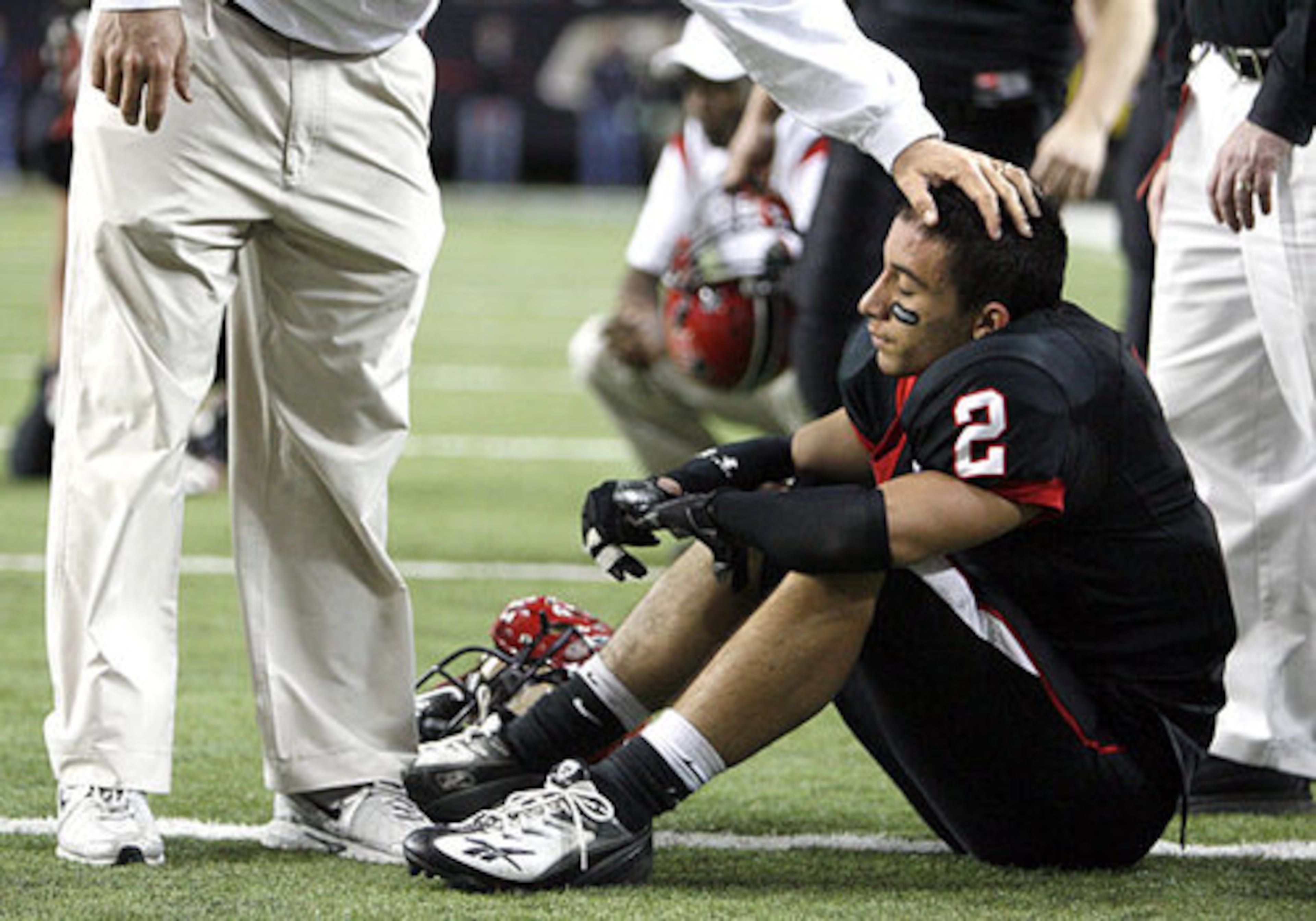 Keep your head up. Flowery Branch linebacker David DeLeon (2) gets consoled by an assistant coach.