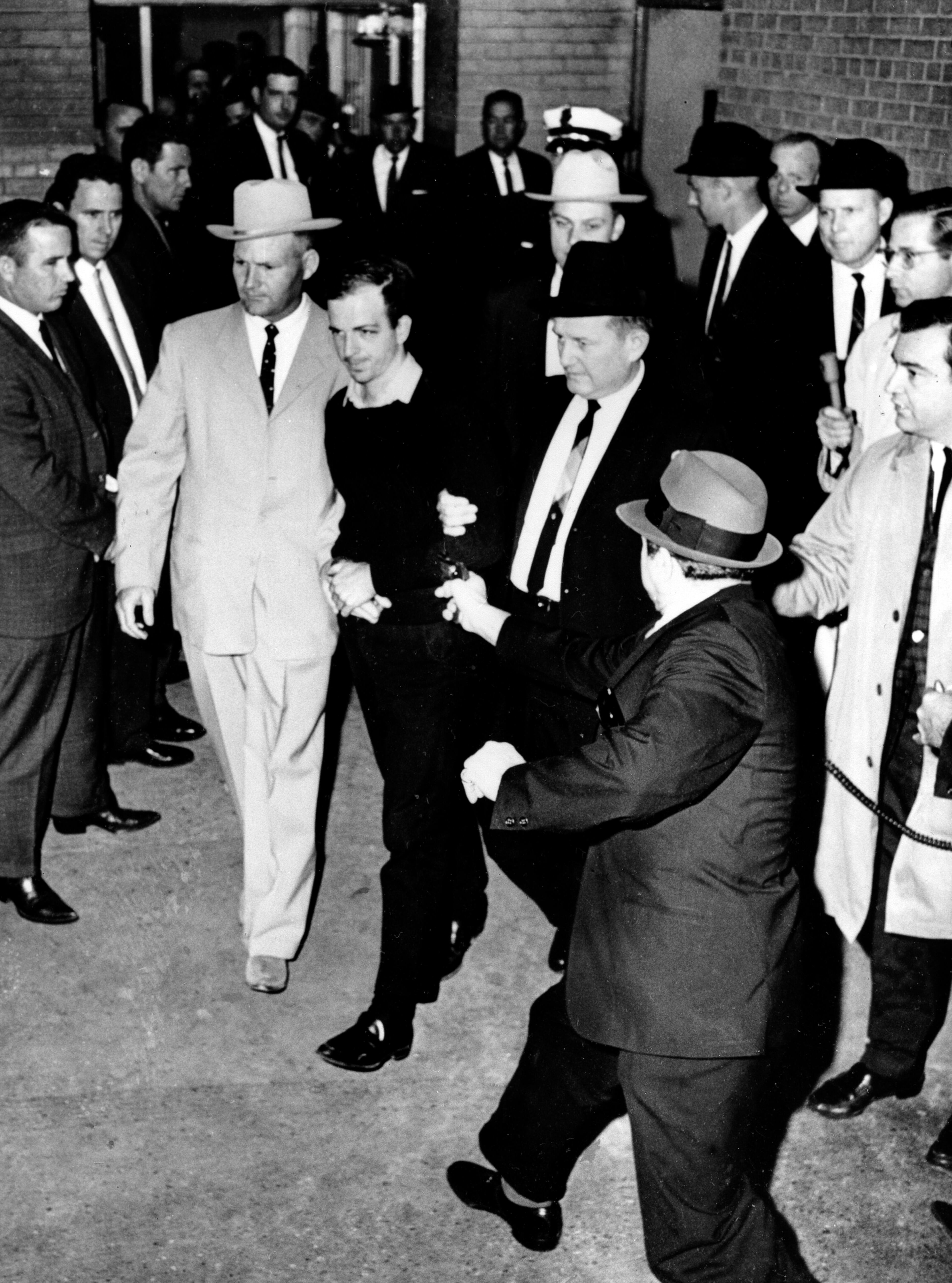 FILE - In a Nov. 24, 1963, file photo President John F. Kennedy assassin Lee Harvey Oswald, center in handcuffs, is shot by Jack Ruby, foreground, in the underground garage of the Dallas police headquarters. Oswald died at Parkland Hospital several hours later. His body was buried and then exhumed in 1981 to put to rest theories that Oswald's body wasn't actually there. (AP Photo/Jack Beers, File) (AP Photo/The Dallas Morning News, ) MANDATORY CREDIT; MAGS OUT; TV OUT; INTERNET OUT; AP MEMBERS ONLY NO SALES