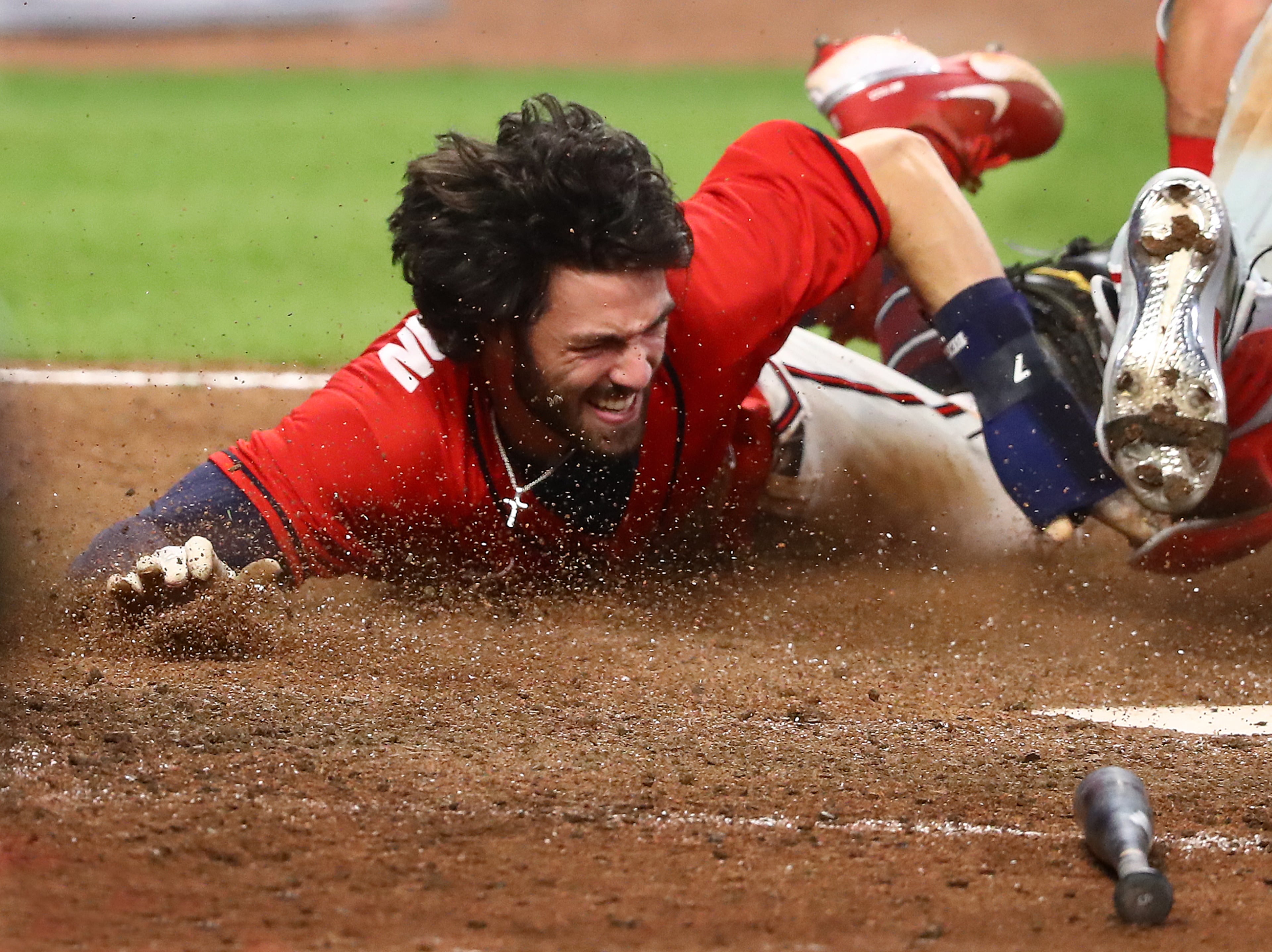 Atlanta Braves' Dansby Swanson dives home around Philadelphia Phillies catcher Andrew Knapp during the ninth inning in a MLB baseball game on Sunday, August 23, 2020 in Atlanta. Swanson was called out after a challenge on the tag stood to end the game 5-4. Curtis Compton ccompton@ajc.com