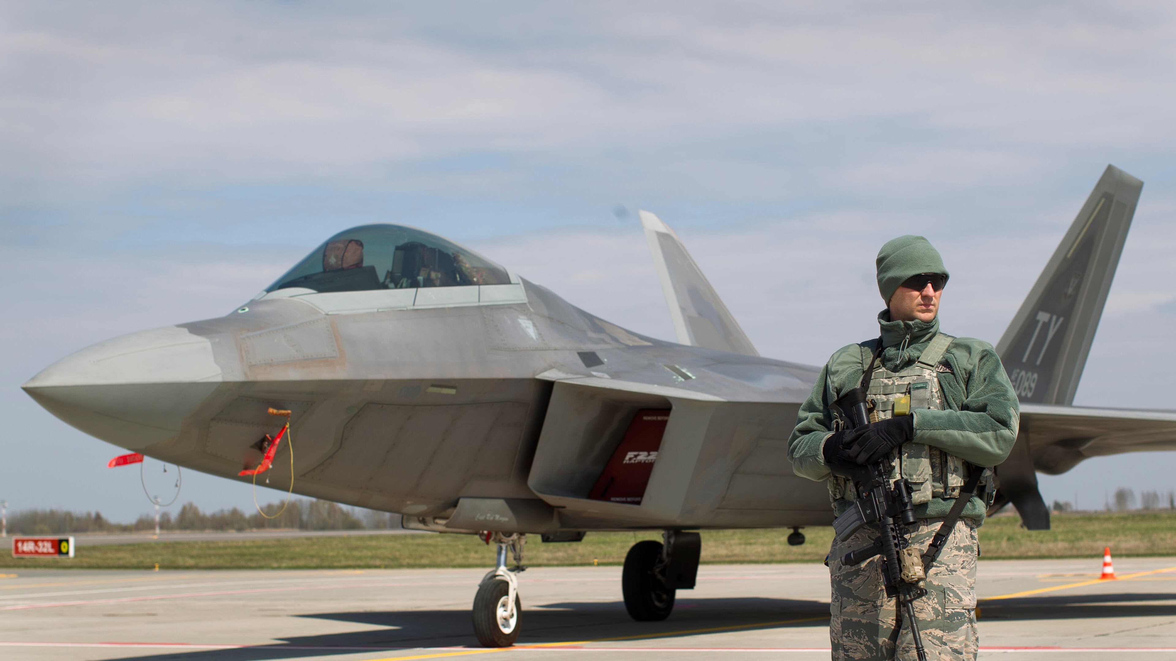 A U.S. military policeman stands in front of a U.S. Air Force F-22 Raptor fighter jet at the Siauliai airbase, some 144 miles east of Vilnius, Lithuania, on Wednesday. This and another Raptor arrived from their base in Britain as a show of force to help Baltic members protect their borders with Russia. AP/Mindaugas Kulbis
