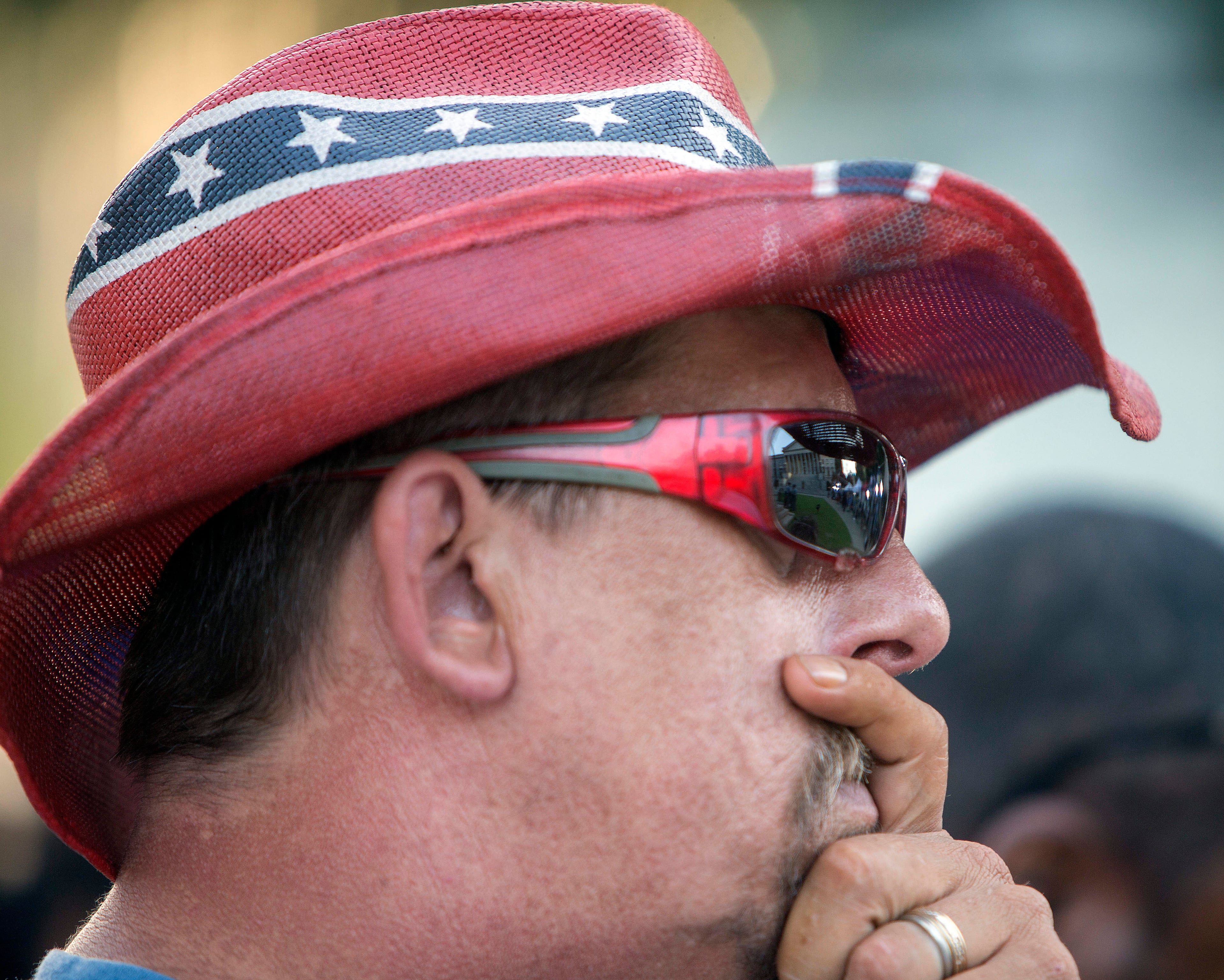 John Blankenship, of Granite Falls, N.C., wears a rebel flag themed hat as he waits for the Confederate battle flag to be removed from the grounds of the State House in Columbia, S.C., the morning of July 10, 2015. In a historic moment for South Carolina, the flag is set to be removed from its 30-foot pole on Friday morning. (Stephen B. Morton/The New York Times)