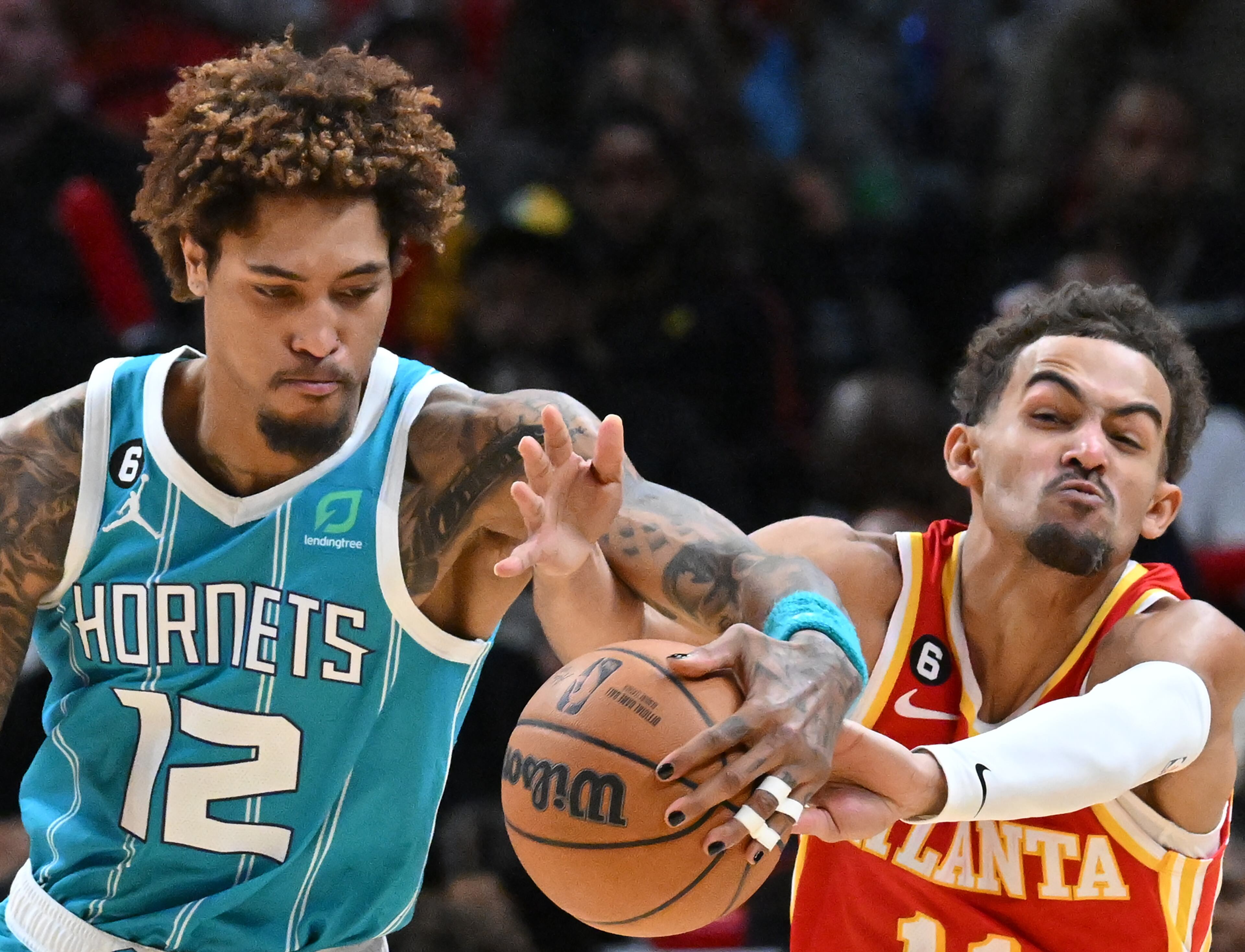 Charlotte Hornets guard Kelly Oubre Jr. (12) and Atlanta Hawks guard Trae Young fight for a loose ball during the second half of an NBA basketball game at State Farm Arena on Sunday, Oct. 23, 2022. The Hornets won 126-109. (Hyosub Shin / Hyosub.Shin@ajc.com)