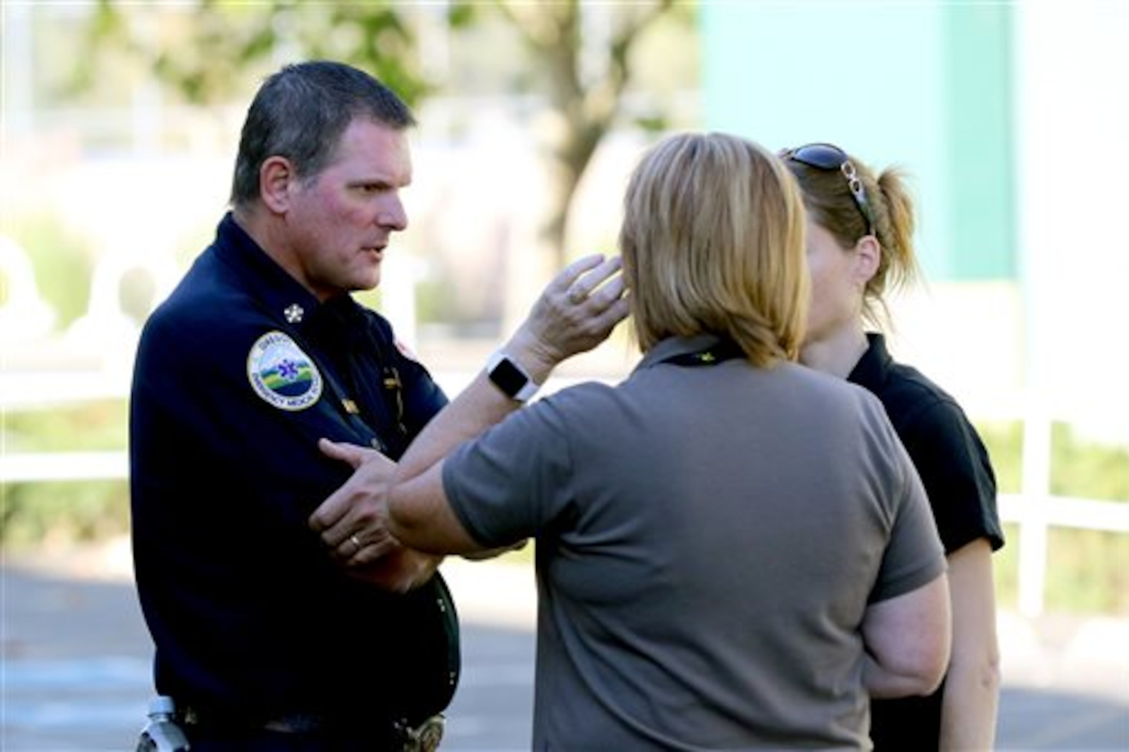 Click on this link for updates on the Oregon school shooting. An Oregon Emergency Medical Technician, left, speaks with others at the county fairgrounds in Roseburg, Ore., Thursday, Oct. 1, 2015, following a deadly shooting at nearby Umpqua Community College. Students and faculty were bused to the fairgrounds where counselors were available and some parents waited for their children. (AP Photo/Ryan Kang)