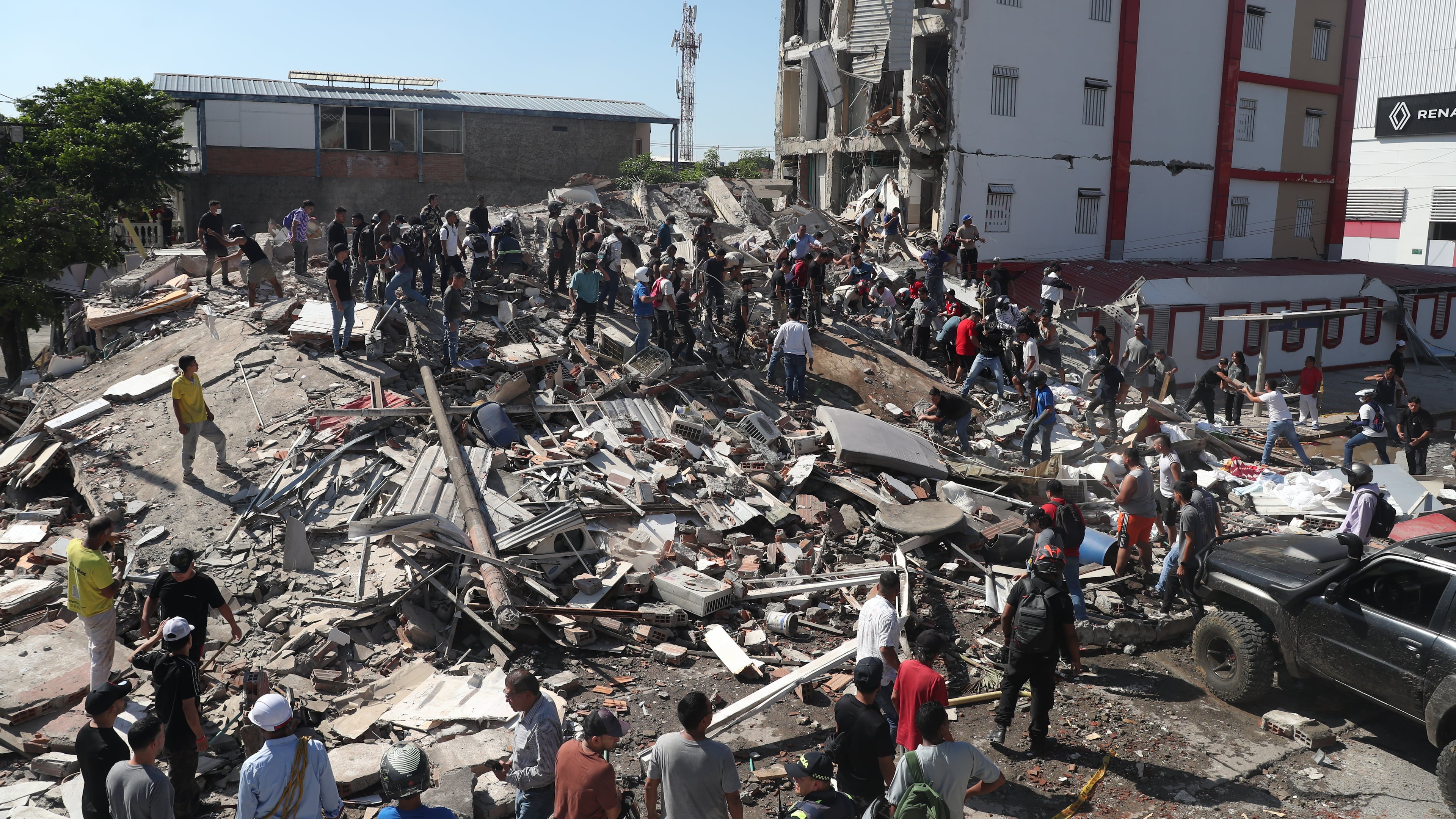 Residents and rescue workers search through the rubble of a collapsed building after an earthquake struck Cali, Colombia, Monday, Aug. 10, 2026. (AP Photo/Santiago Saldarriaga)