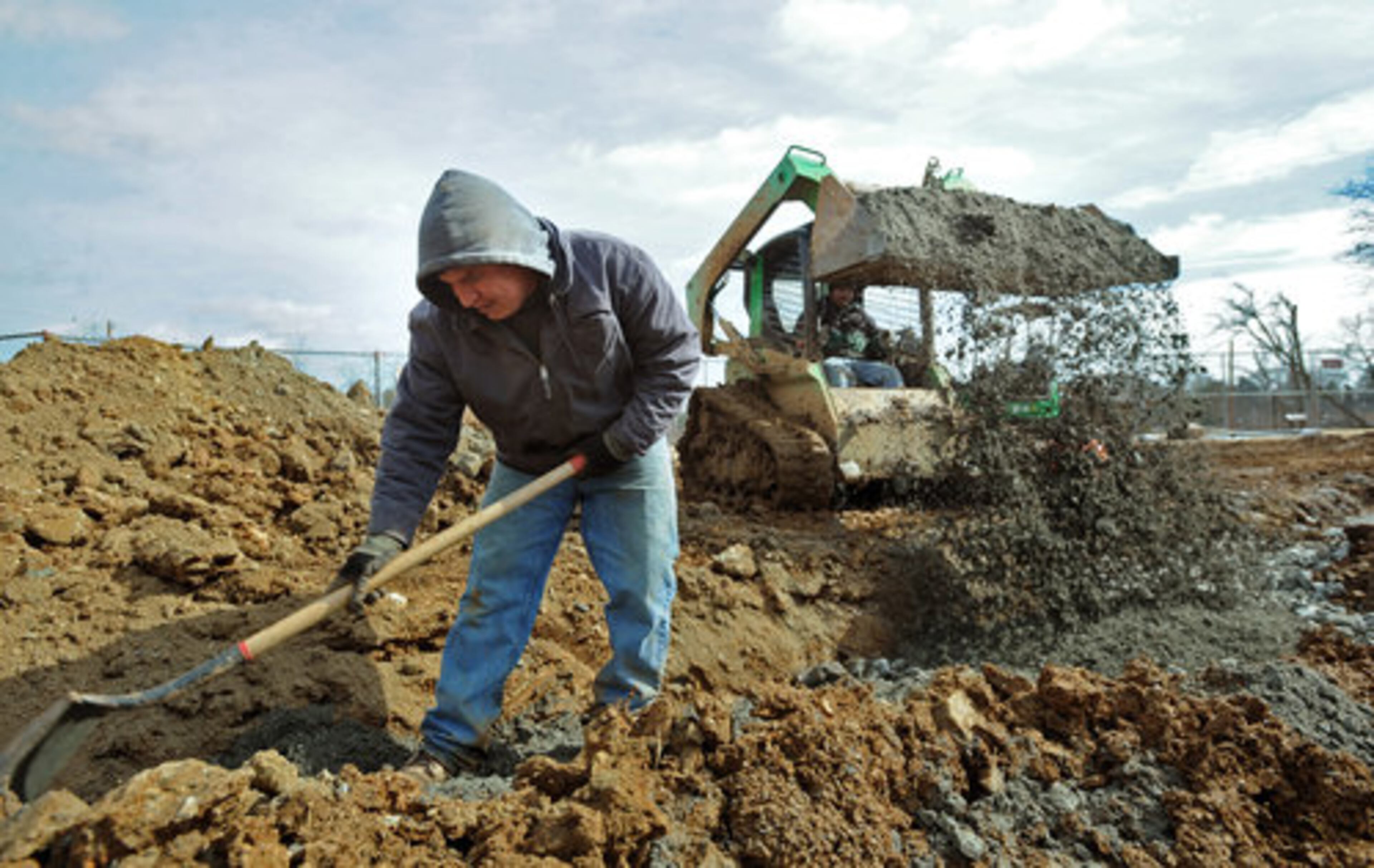 Alejandro Herrera (left) and his brother Jualian Herrera, both employees at Mathias Corp., work on increasing size of the fountain at Lillian Webb Park in Historic Norcross.