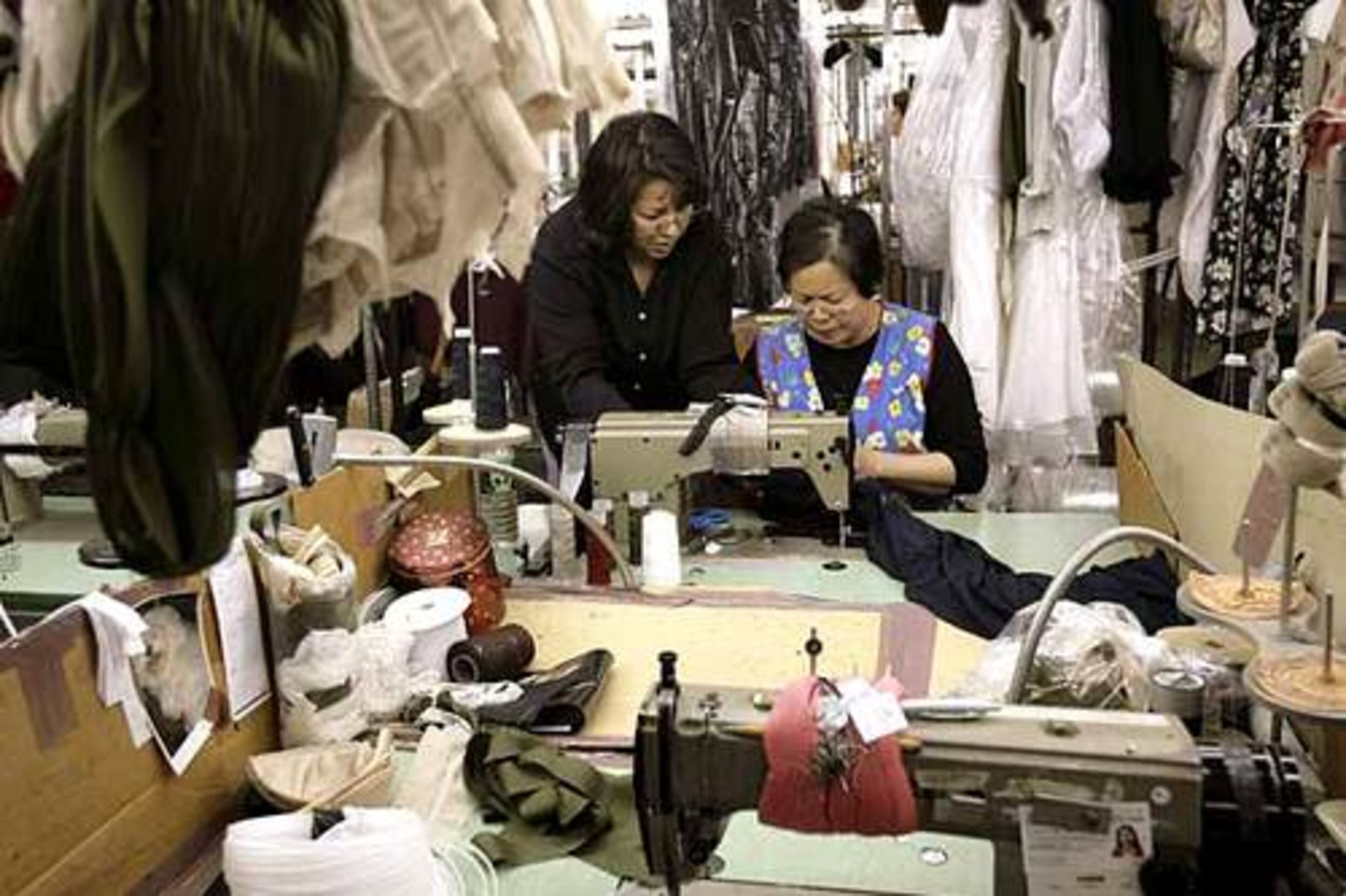 Women are surrounded by garments and sewing machines at the Dalma Dress Manufacturing Co. in New York's Garment District.