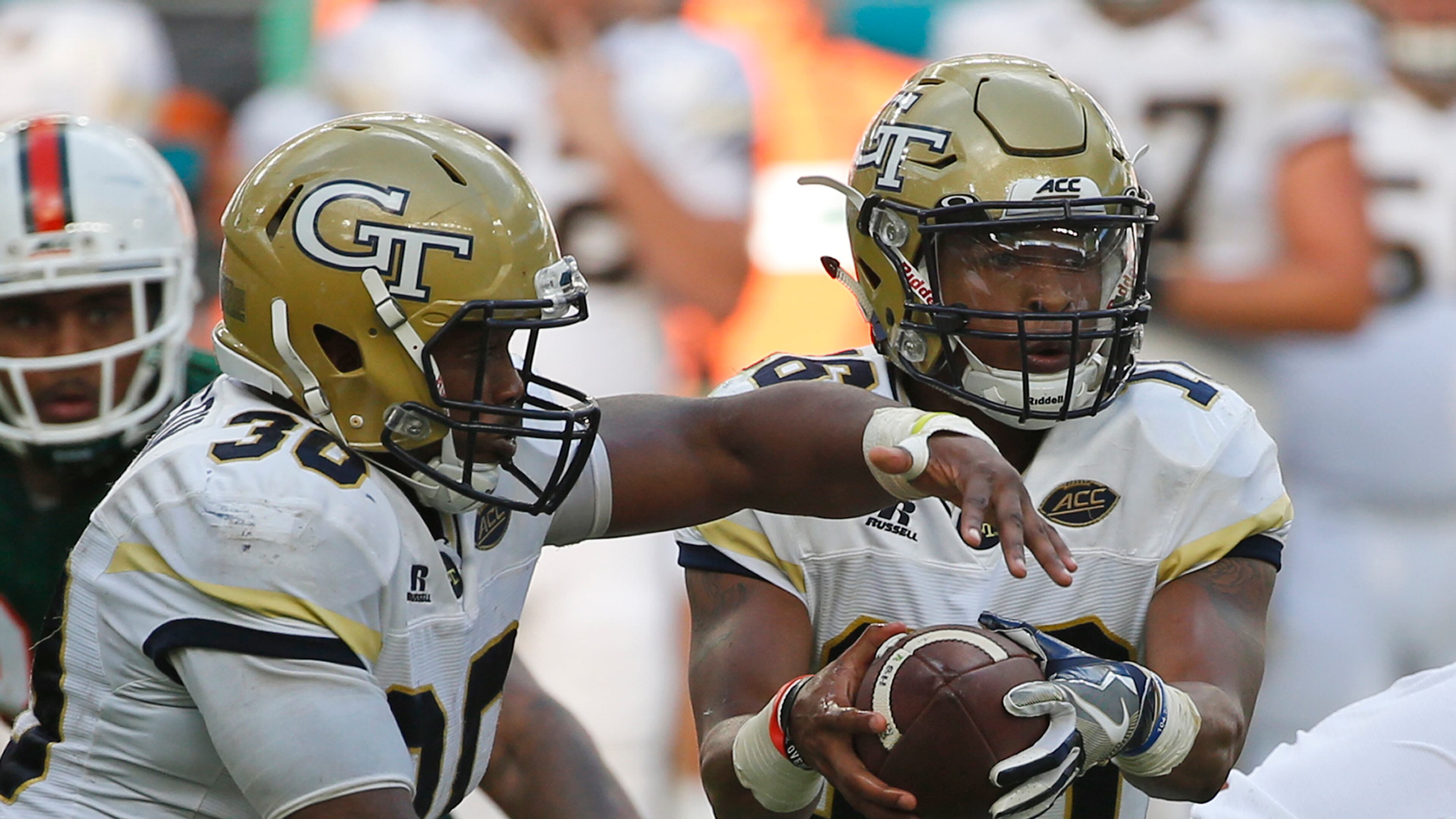Jackets QB TaQuon Marshall fakes a handoff to KirVonte Benson (30) during the first half of Saturday's game. (AP Photo/Wilfredo Lee)
