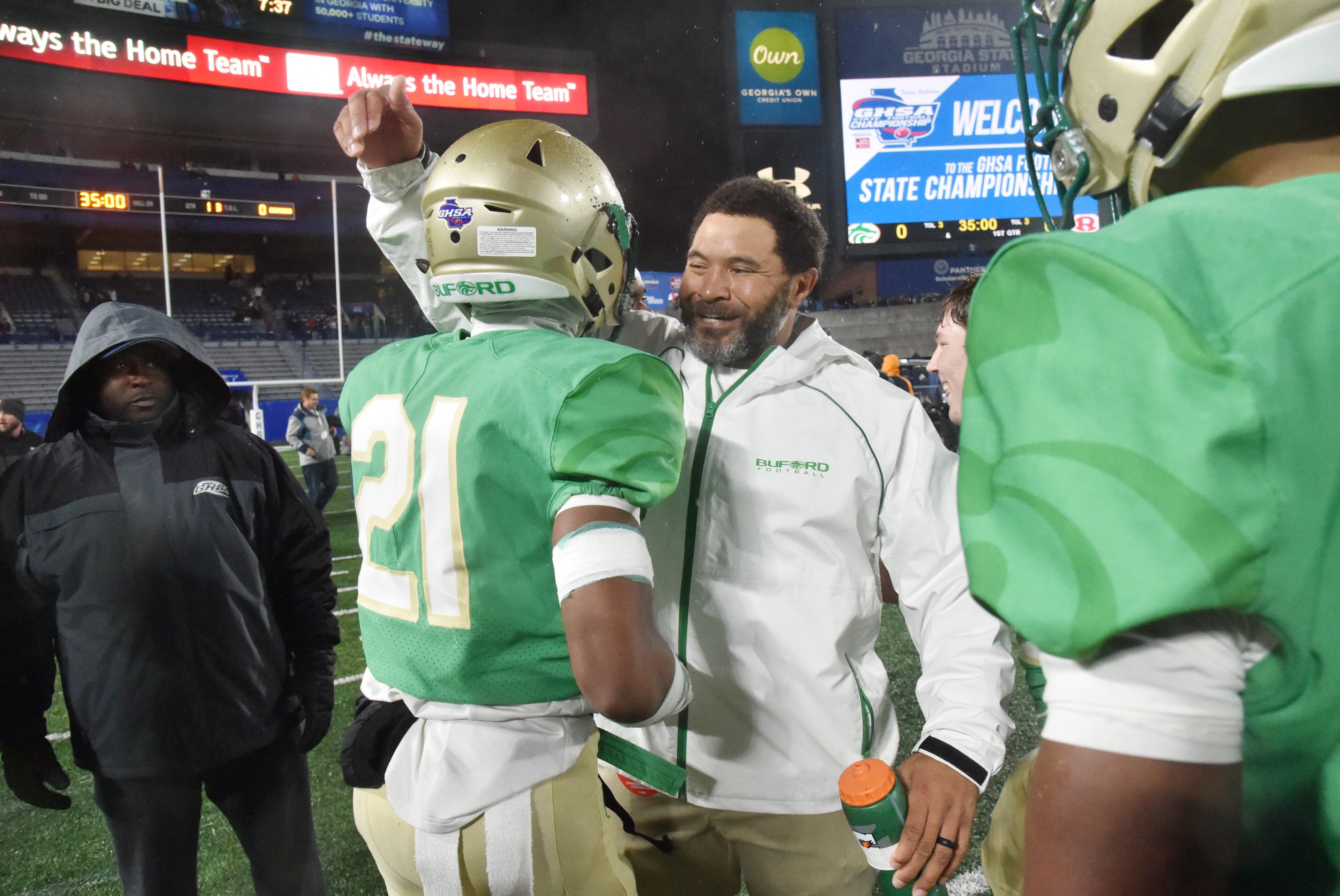 Coach Bryant Appling (right) celebrates with Buford cornerback Jalen Huff (21). (Hyosub Shin / Hyosub.Shin@ajc.com)