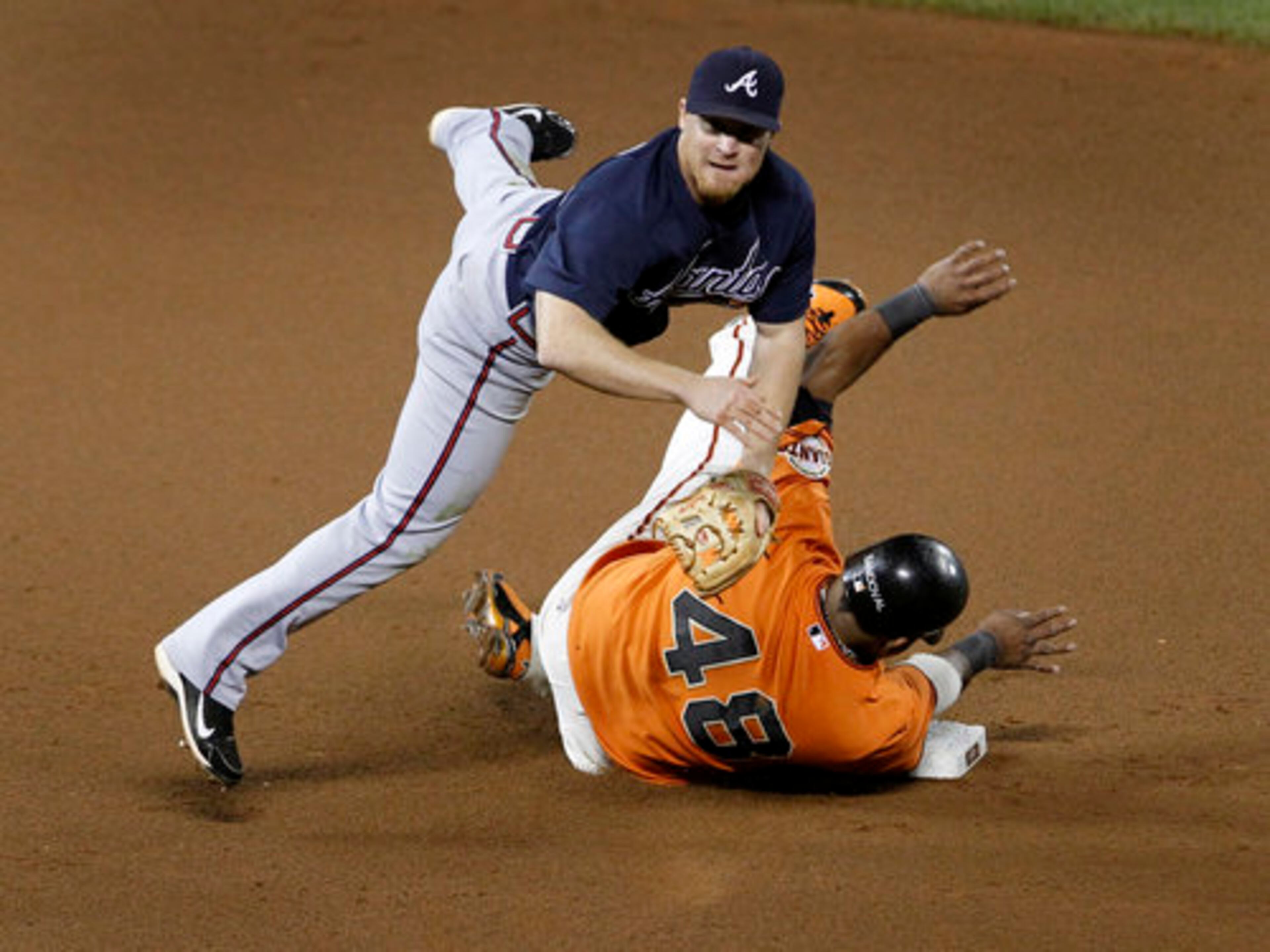 Pablo Sandoval is out at second base but breaks up a double play throw by second baseman Brooks Conrad in the 7th inning.